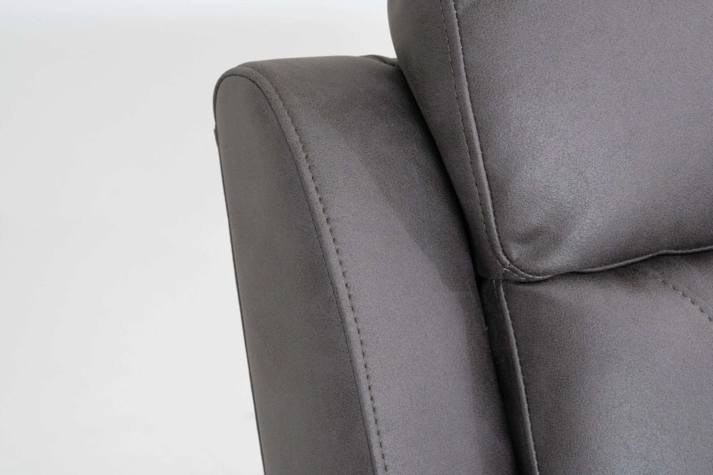 Close-up of a gray upholstered sofa armrest and back cushion on a white background.
