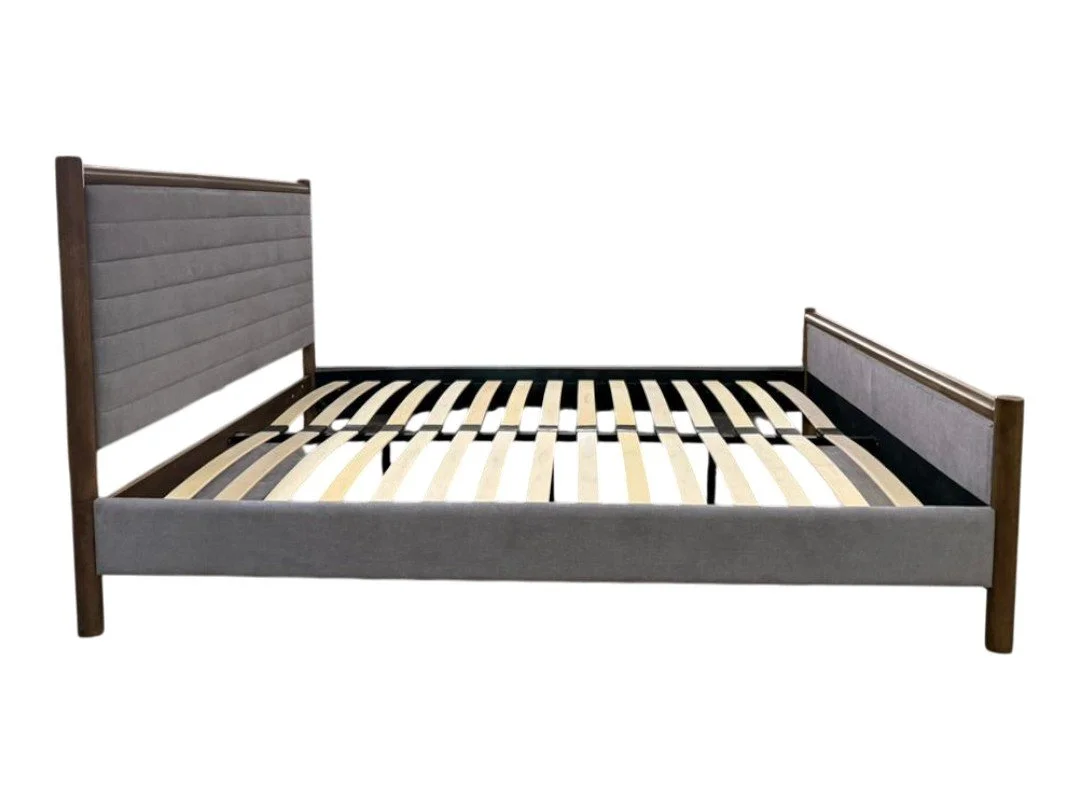 A wooden bed frame with upholstered grey headboard and footboard, and slats for mattress support, isolated on a white background.