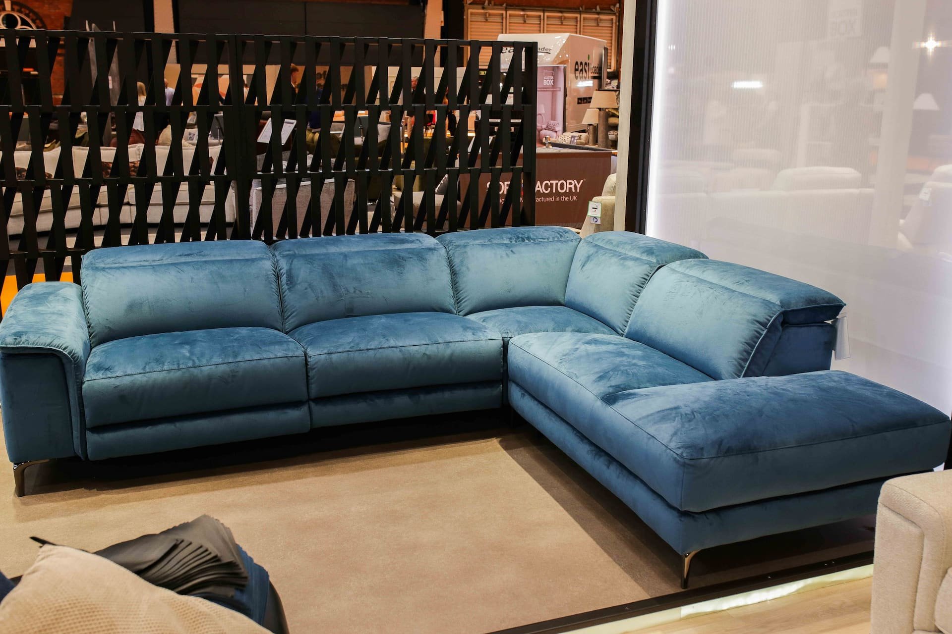 Blue velvet sectional sofa on display in a furniture store.