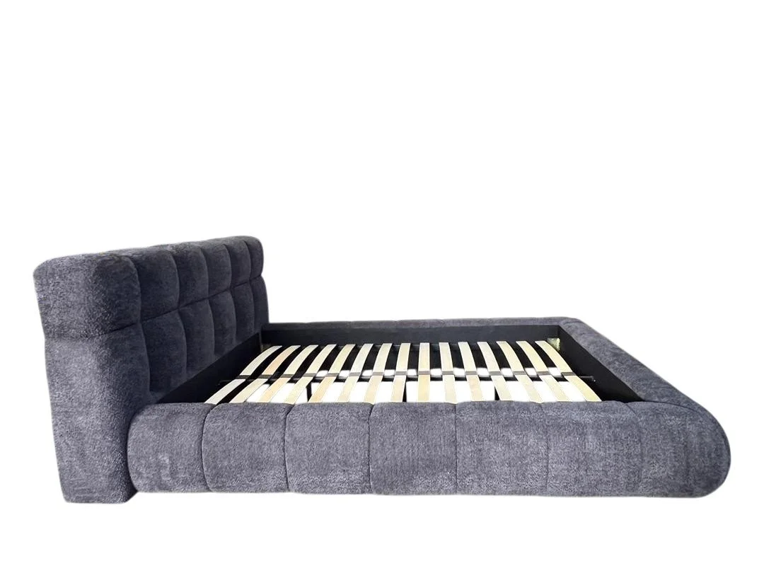 Gray upholstered bed frame with a tufted headboard and slatted base, isolated on a white background.