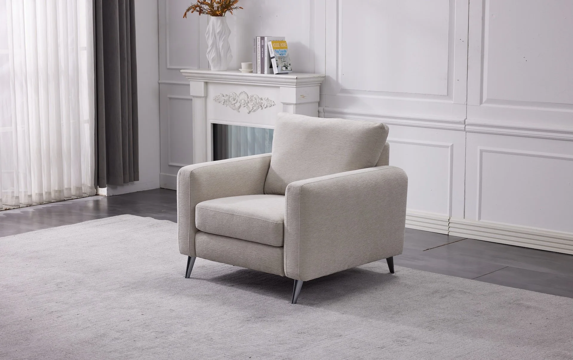 A beige armchair positioned on a light-colored rug in a modern living room with white paneled walls and a decorative white fireplace mantel.