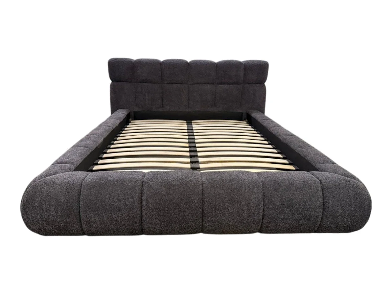 A dark gray upholstered bed frame with a padded headboard and wooden slats for mattress support, isolated on a white background.
