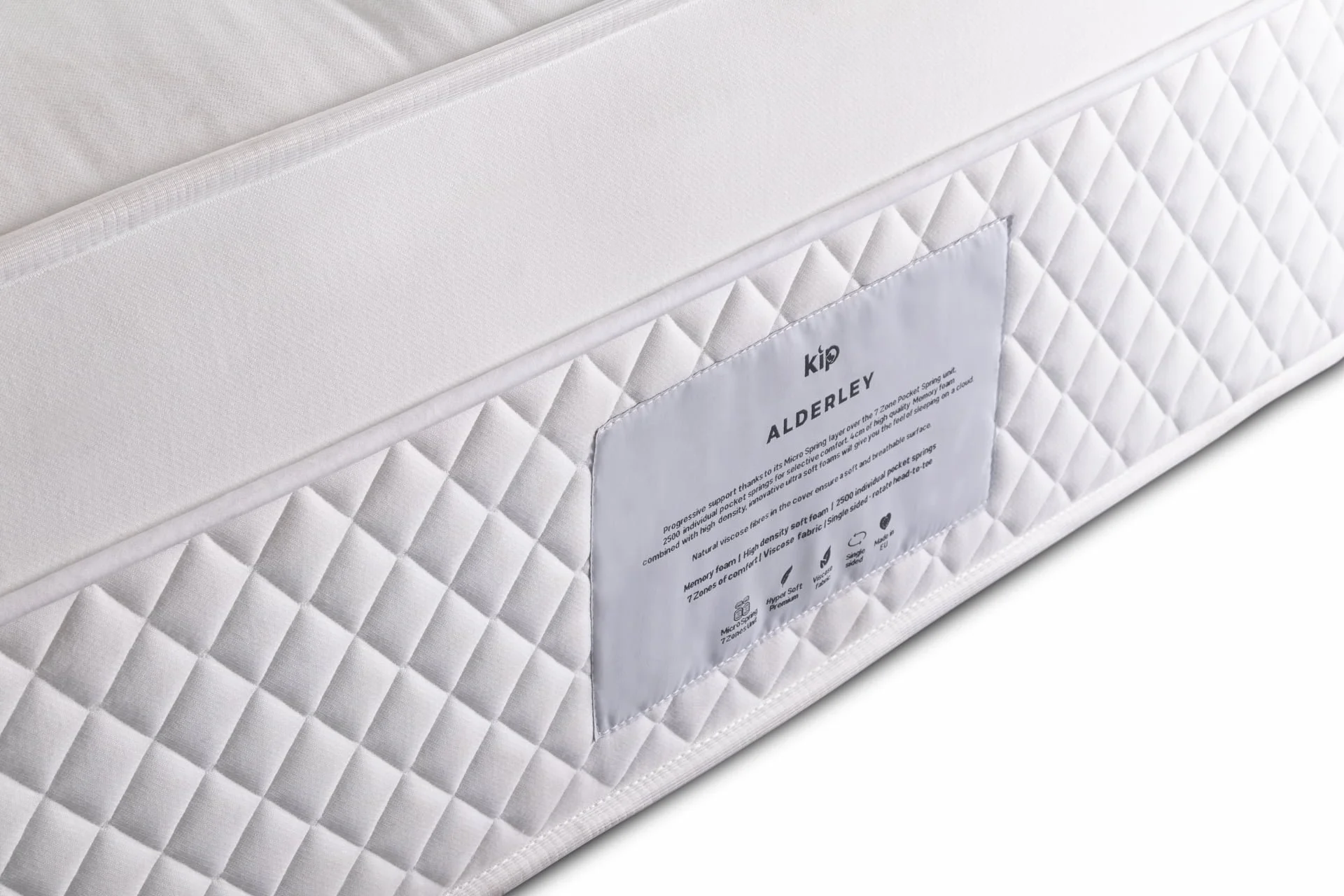 Close-up view of a white mattress with a diamond-quilted surface and a label attached to its side, displaying the brand name Allderley and product details.