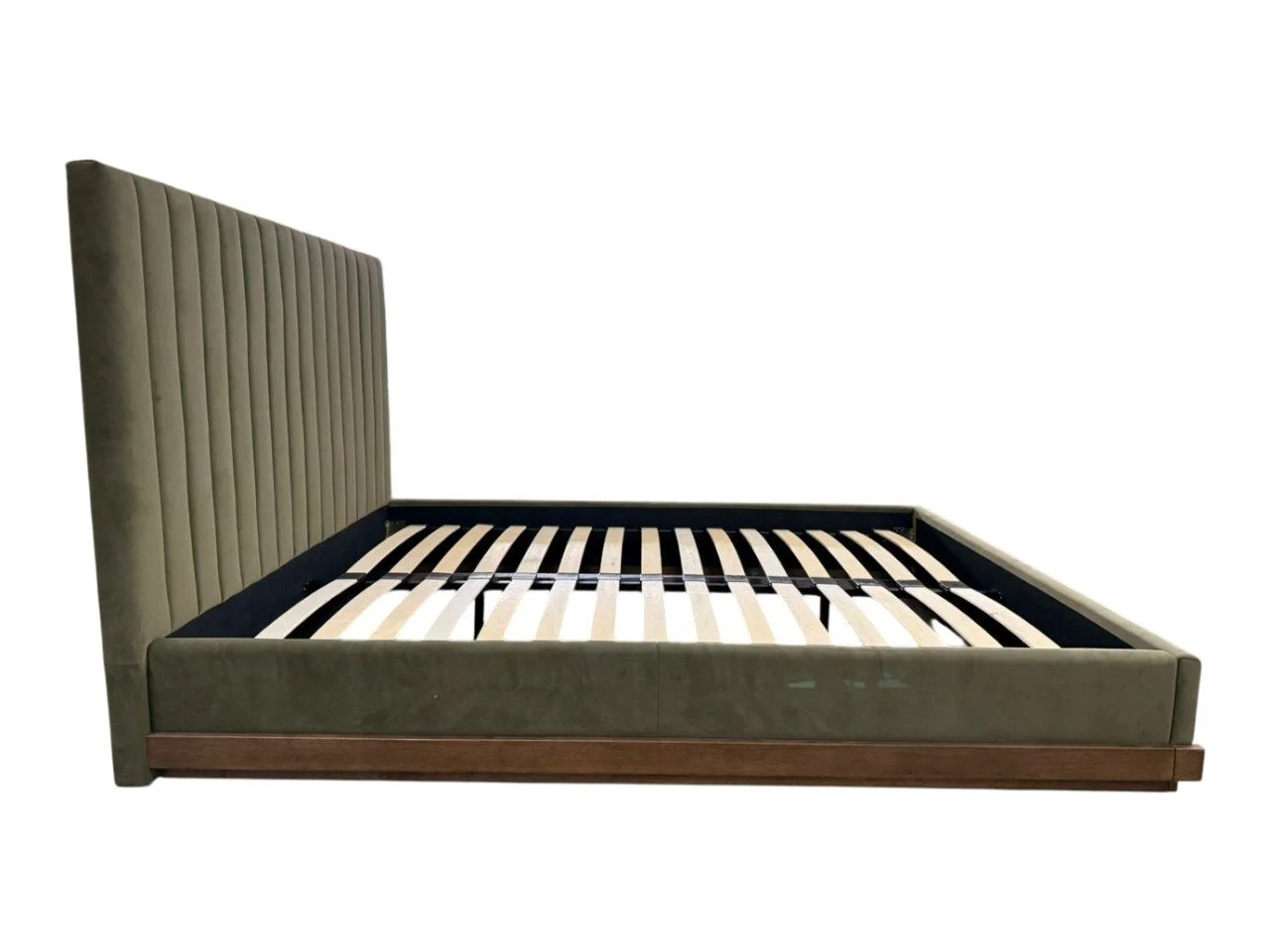 A bed with a tall, padded, beige headboard and a wooden frame, without a mattress, showing black support slats.