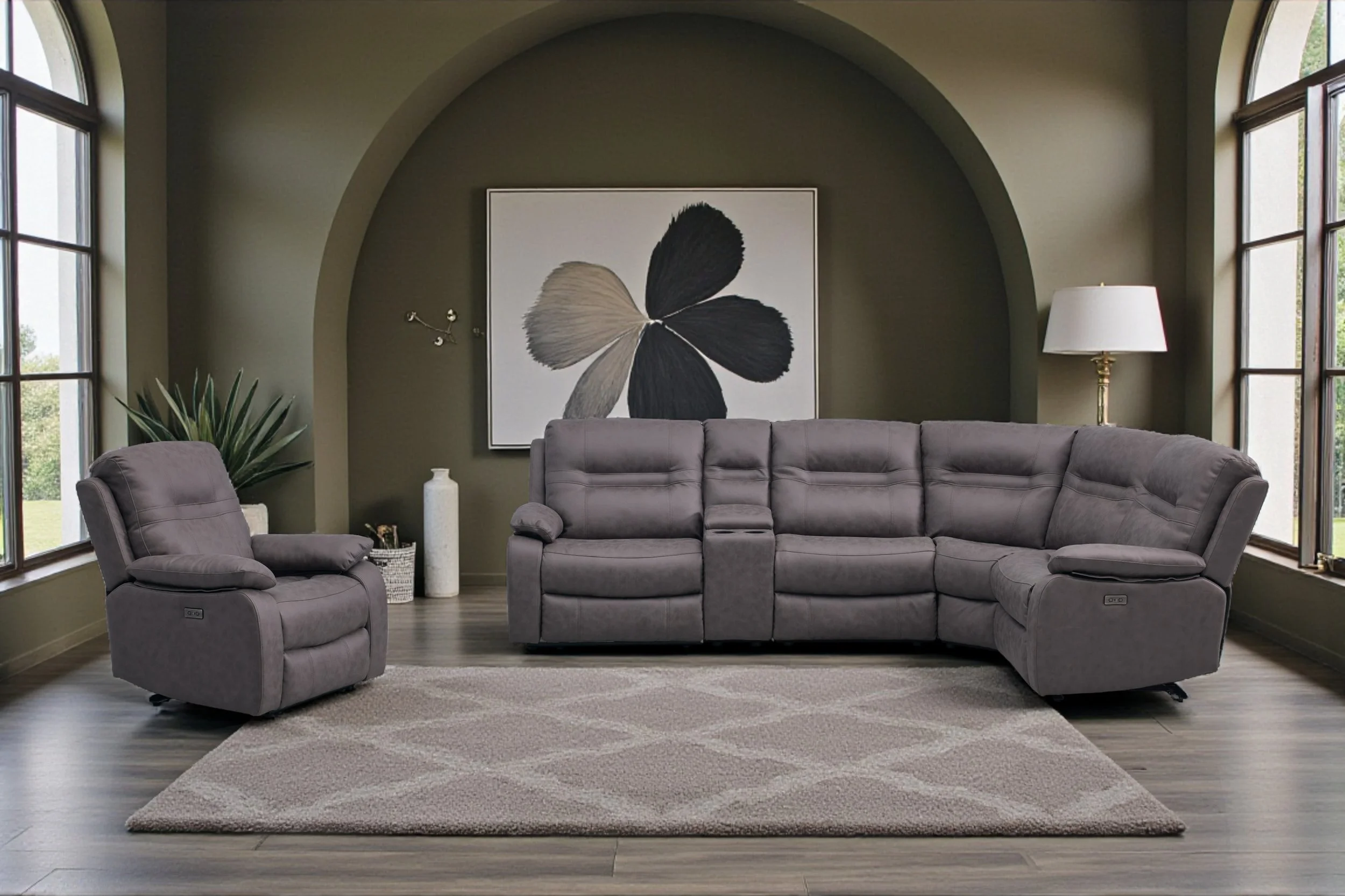 Gray sectional sofa in a living room with white walls, a beige curtain, and a large window, with a small side table and a framed abstract art piece.