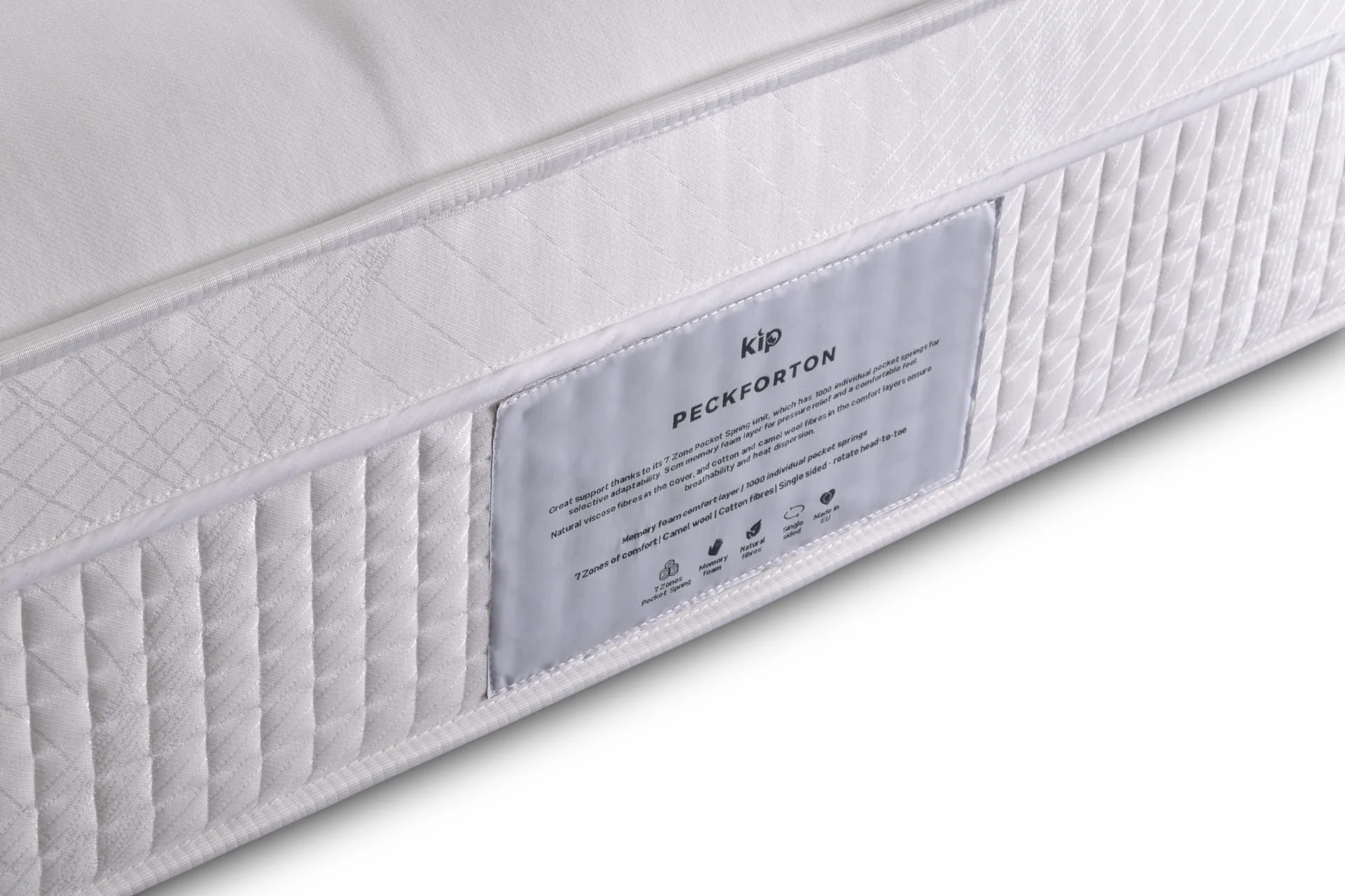 Close-up of a white mattress with a label showing brand and product details.