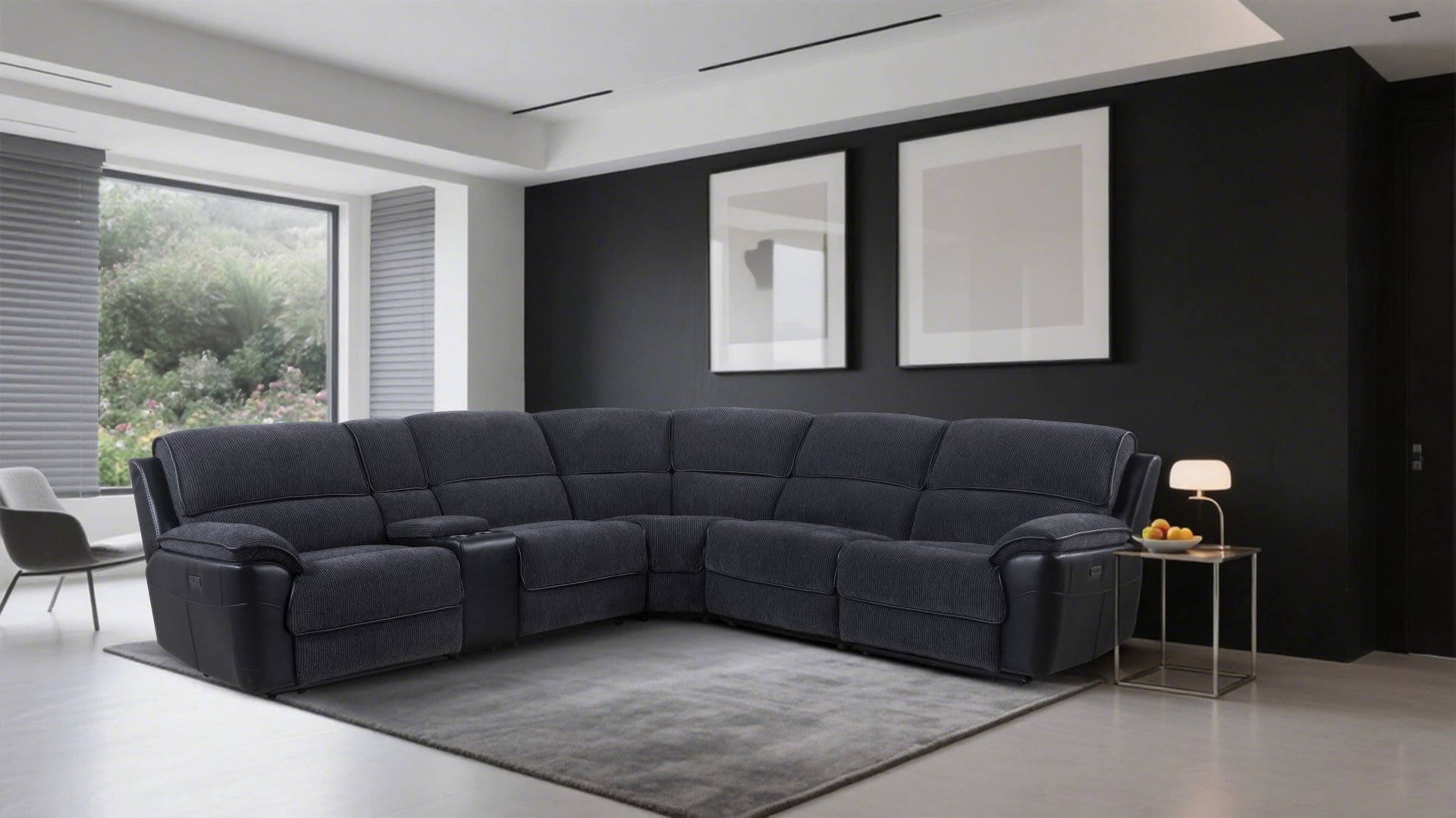 Modern living room with a black sectional sofa, a side table with a small lamp and bowl of fruit, large window with blinds, and black accent wall with two white framed artworks.