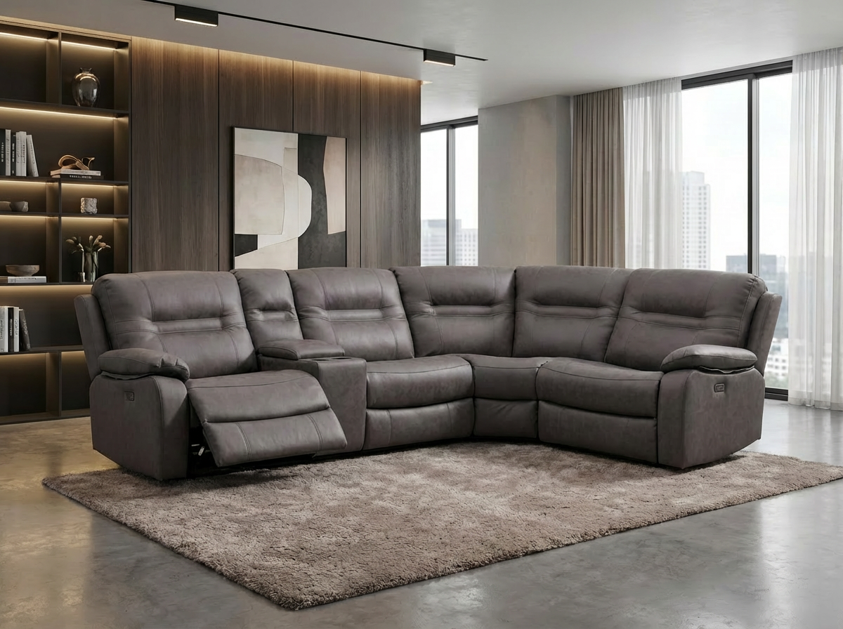 Gray sectional sofa in a living room with white walls, a beige curtain, and a large window, with a small side table and a framed abstract art piece.
