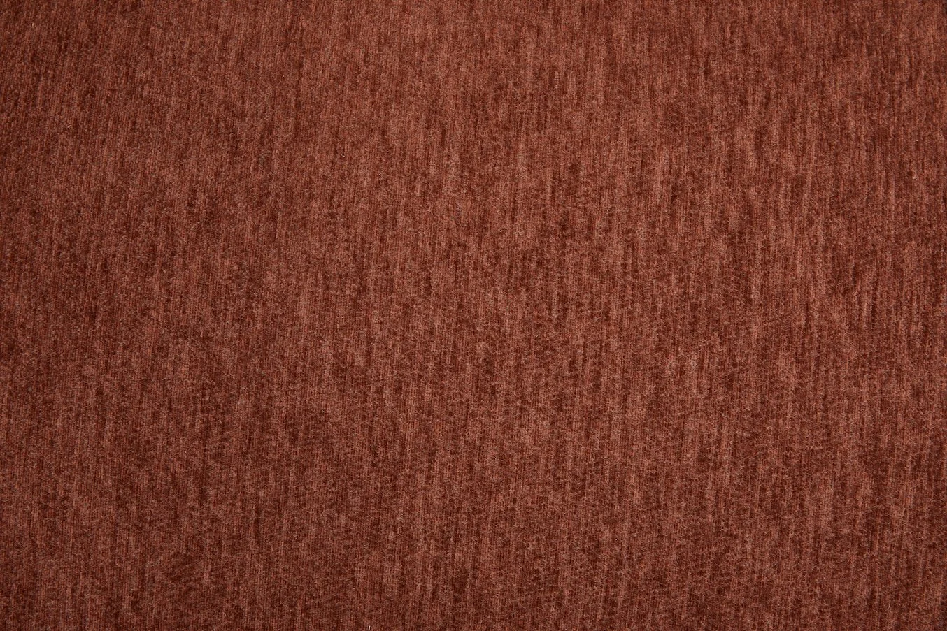Close-up of a textured reddish-brown fabric or material surface.