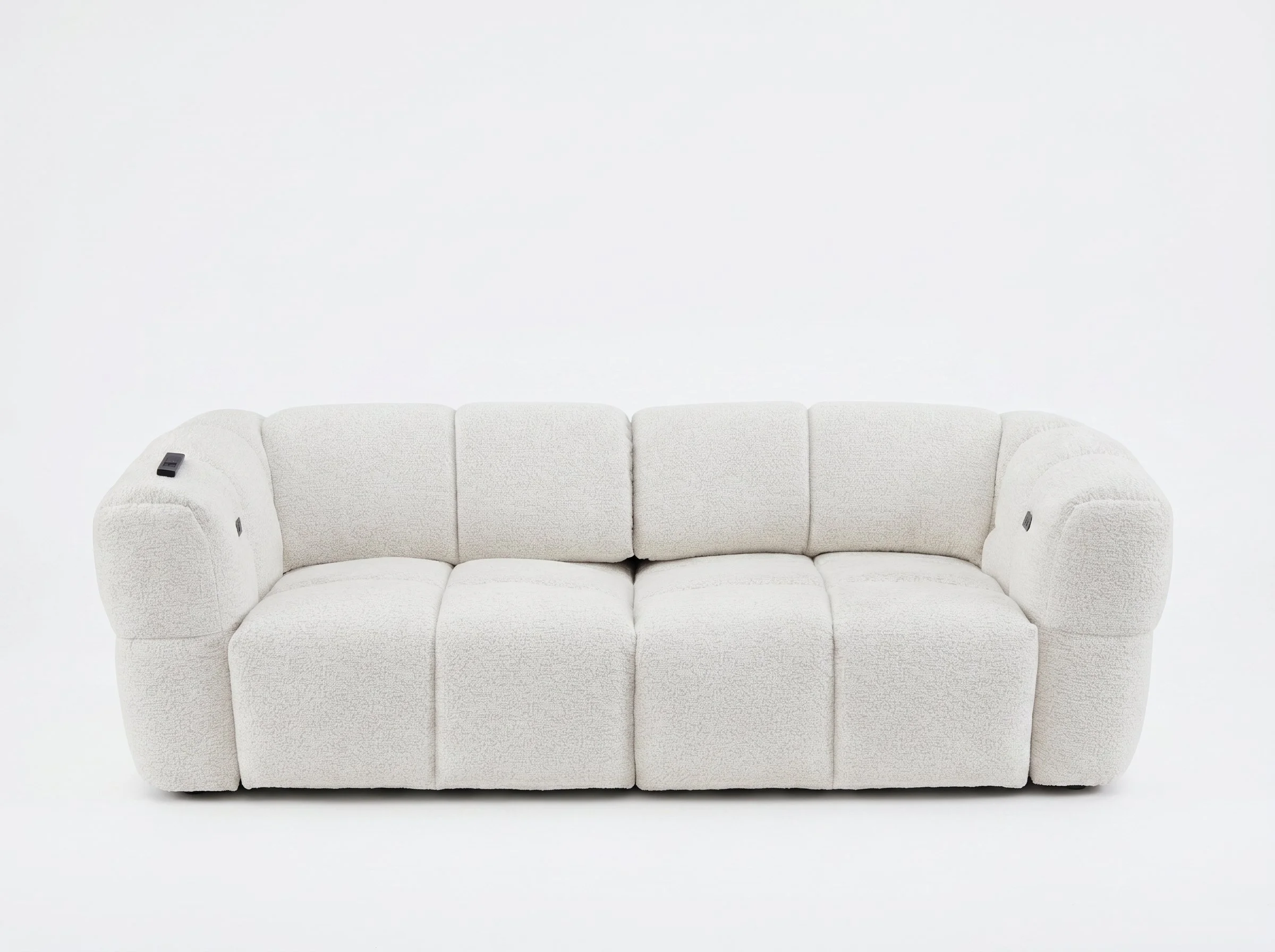 A white, plush three-seater sofa with rolled arms in front of a plain white wall.