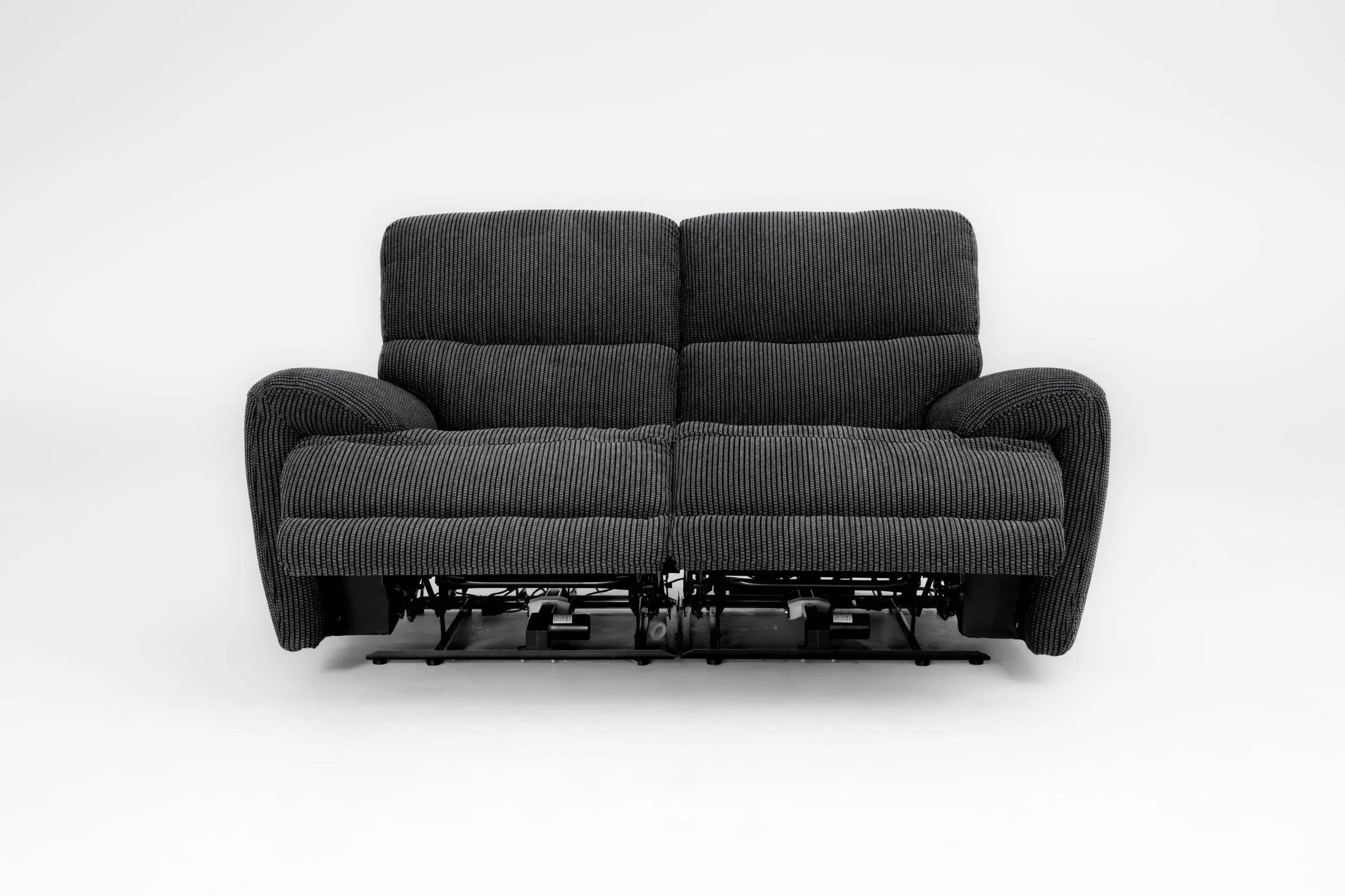 Black fabric sofa with visible reclining mechanisms beneath, isolated against a white background.
