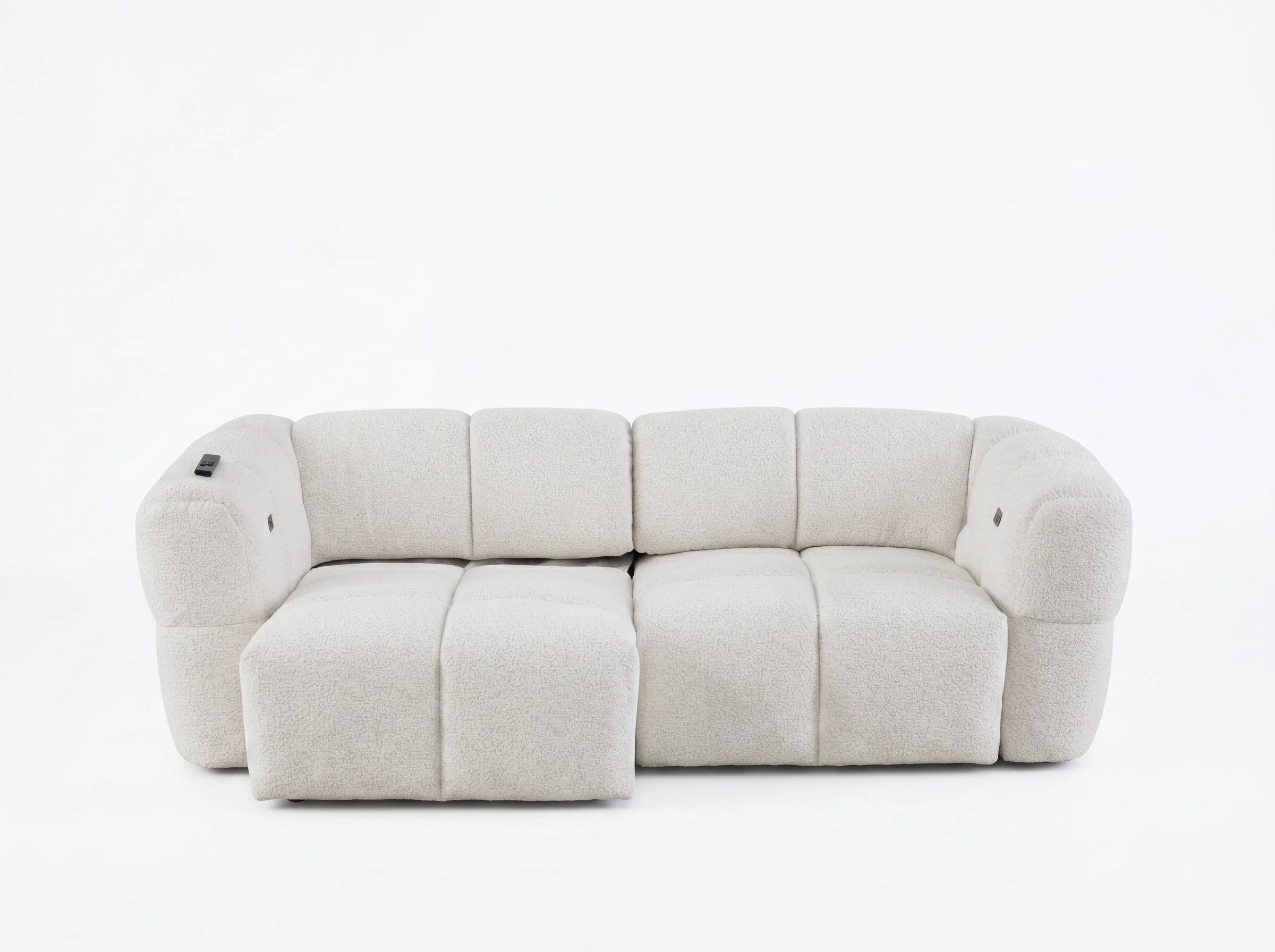 A white sofa with plush cushions and a remote control resting on the armrest, set against a plain white background.