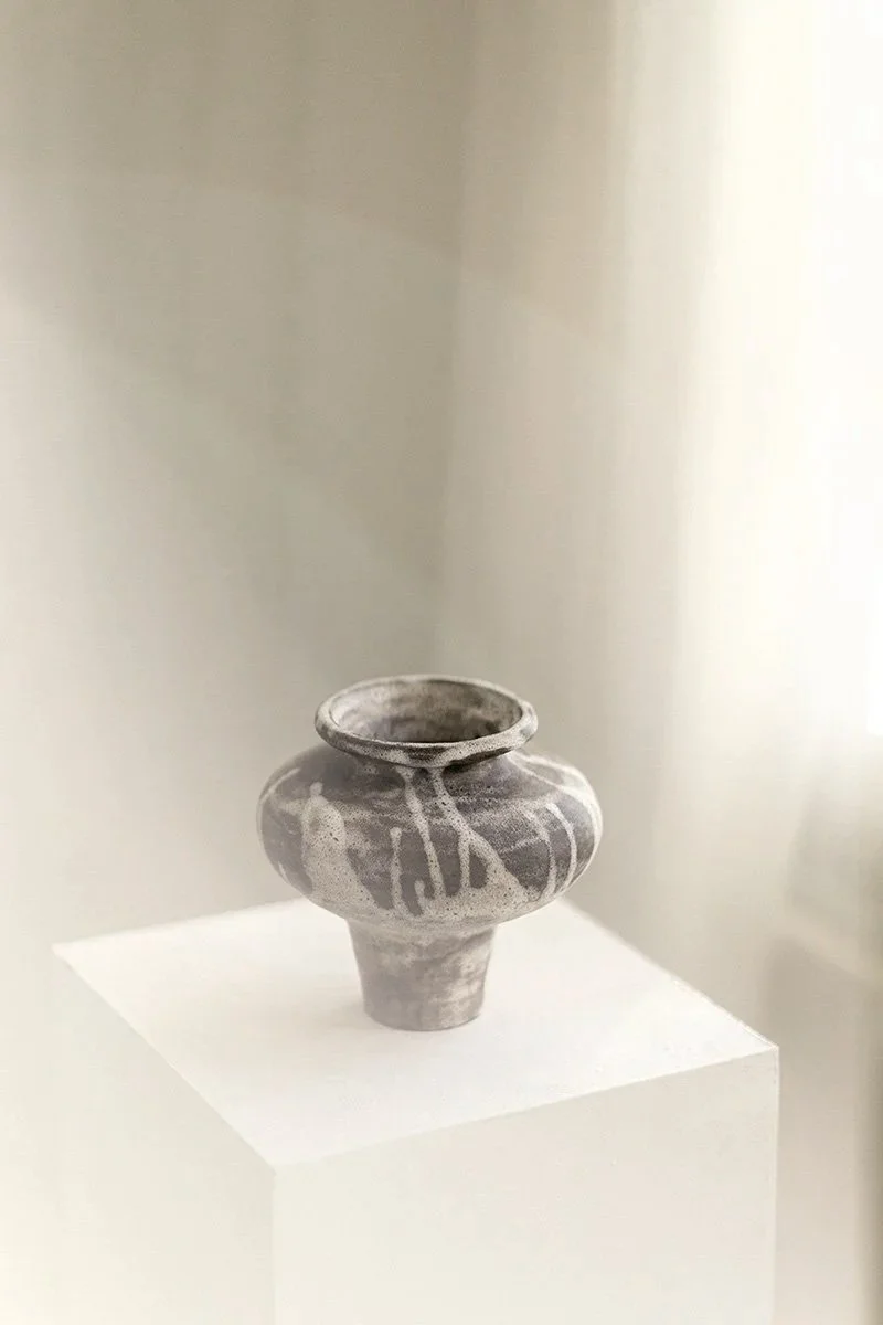 Keraaminen astia tai kuppi, harmaa ja valkoinen kuvio, näytillä museossa tai taidegalleriassa.