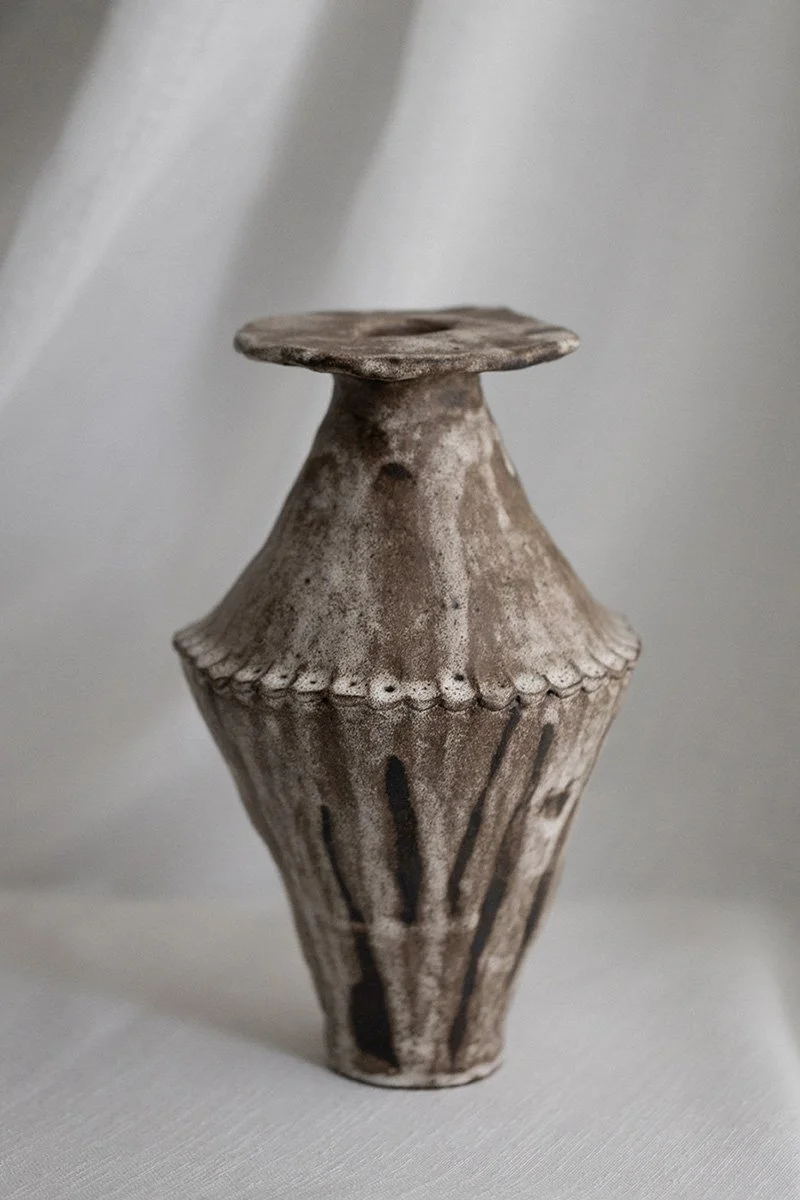 Tumma keramiikkavaasi, kivitavarasavesta. 