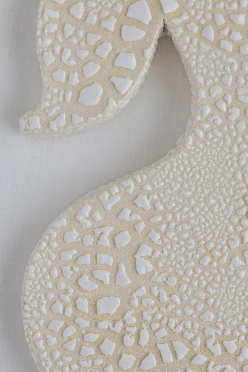 Kuvassa on kaksi decoratiivista vaaleanpunaista ja valkoista geometristä koristetta, jotka muistuttavat keinotekoisia luukiviä, ja ne on sijoitettu valkoiselle taustalle.