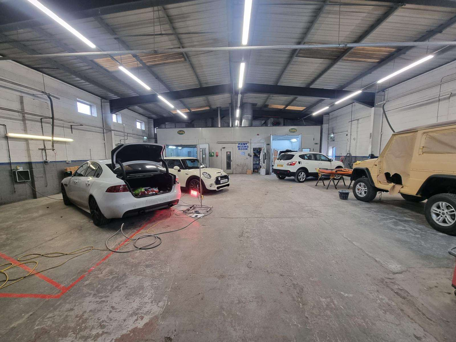 Full shot of inside garage with vehicles getting work done