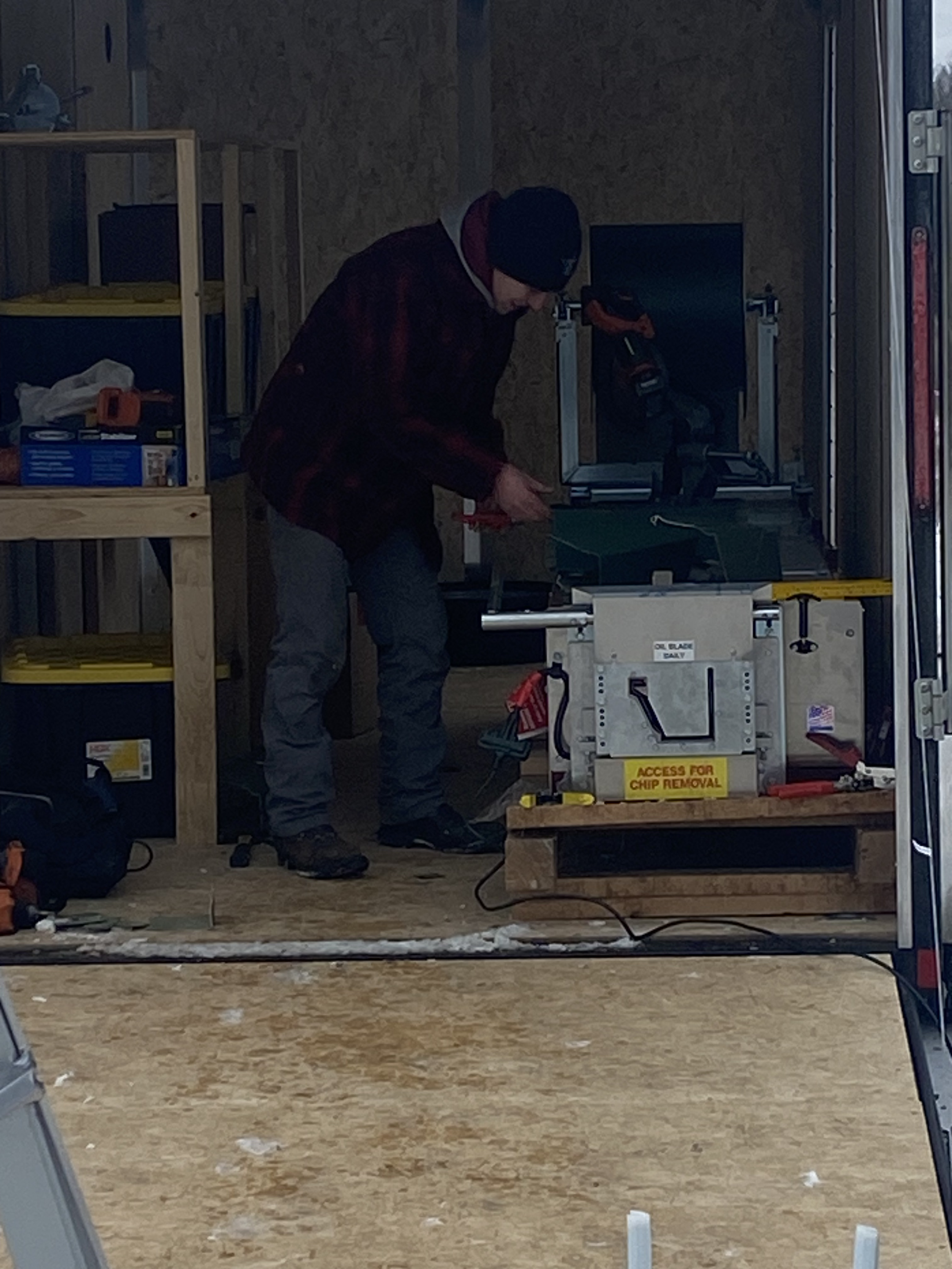 Person working in a workshop with tools and equipment, standing near a chip removal machine labeled 'Access for Chip Removal'.