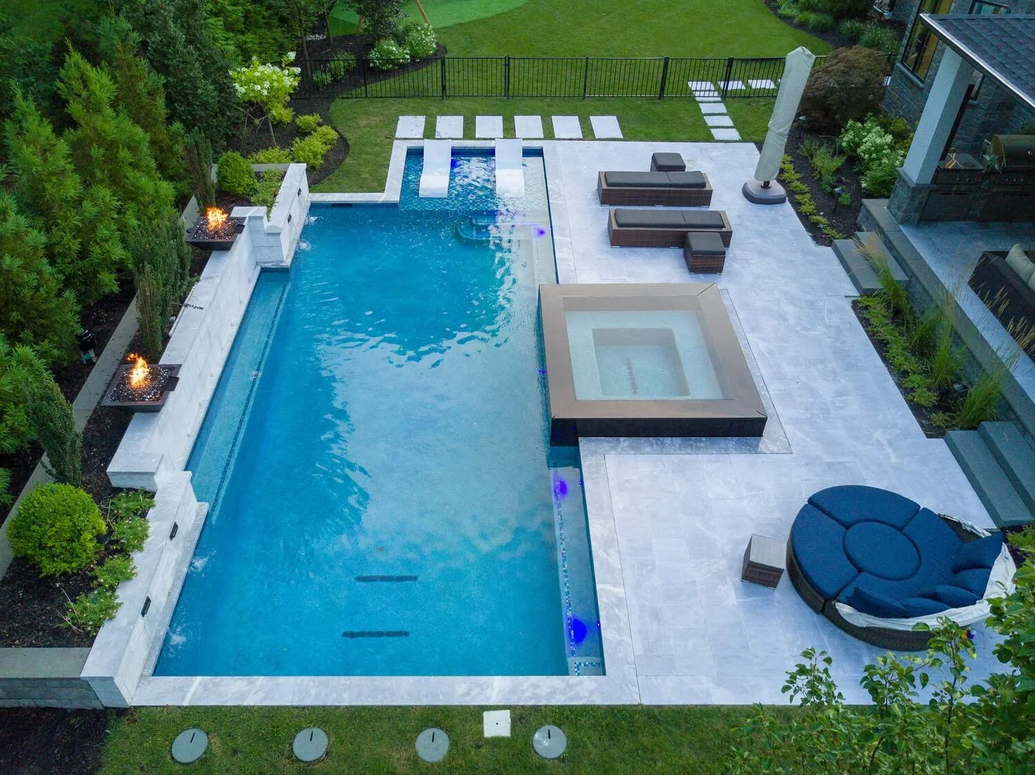 Inground pool with fire features and stone patio