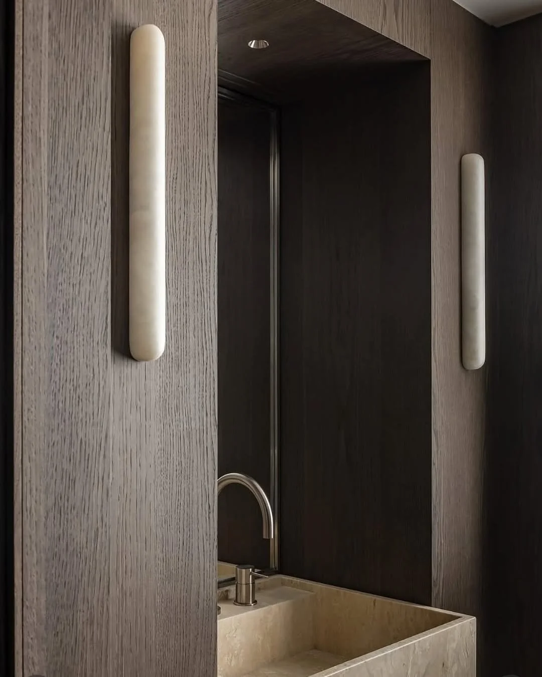 Simplicity carved in stone.
In a refined Parisian bathroom by @felixmillory, two solid &ldquo;Tube 65 - Alabaster&rdquo; lamps from @containestudio
bring a quiet, sculptural glow. Handcrafted in Mallorca, each piece reveals the natural beauty of the 