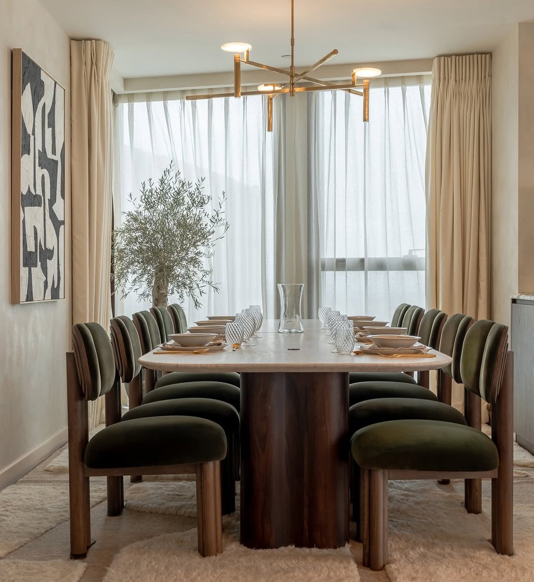 This effortlessly elegant dining space by @daramaison features a sculptural table, rich velvet upholstery and sheer curtains to soften the light, creating a calm, balanced room. Suspended above, the Melange Floating Disc Chandelier by @kellywearstler