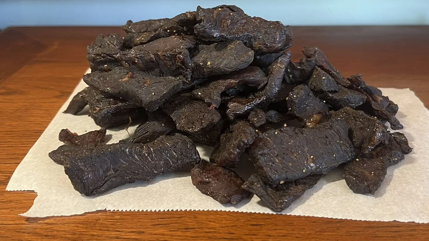 Large pile of beef jerky on parchment paper