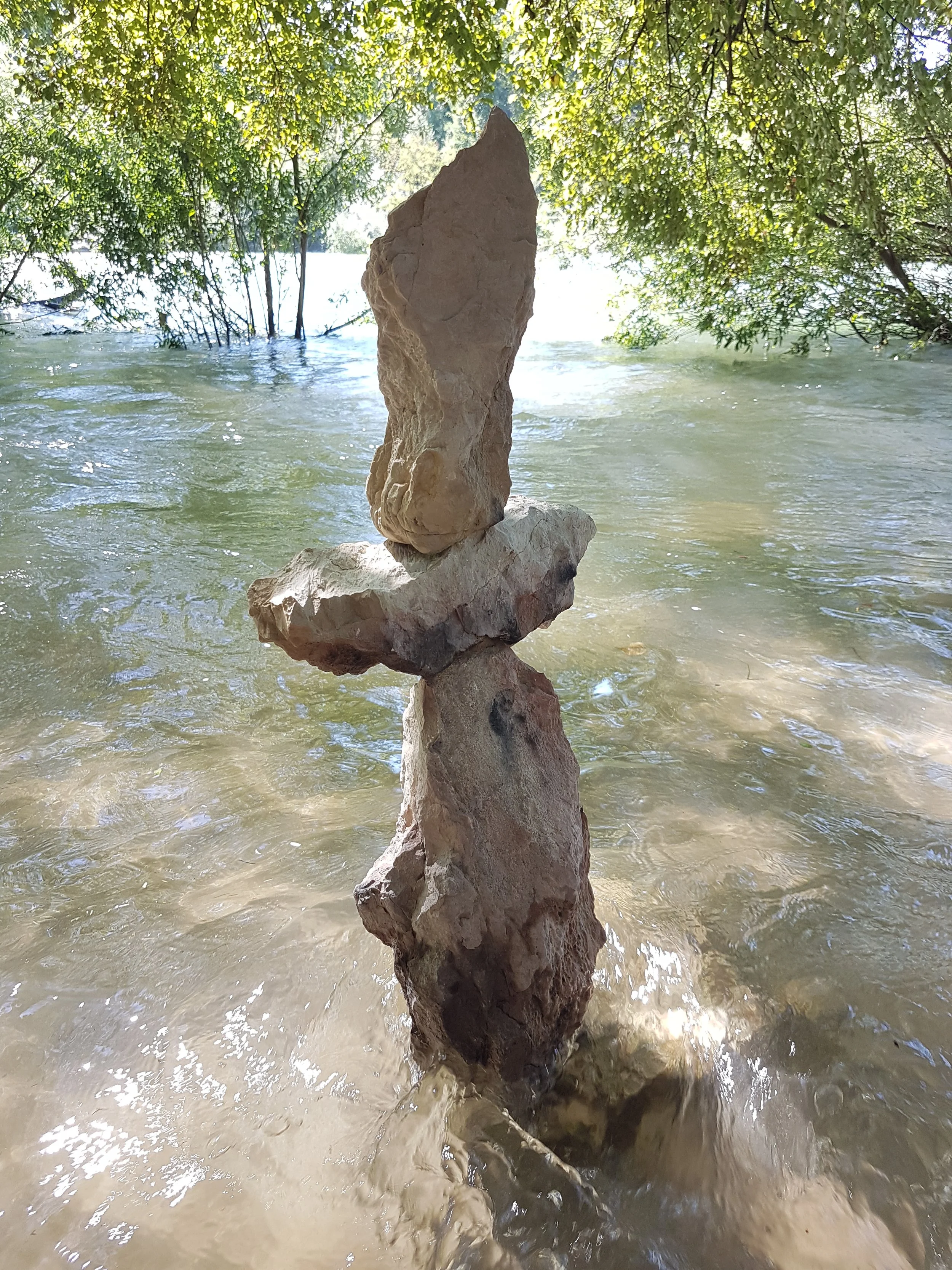 Steinmännchen aus mehreren Steinen am Flussufer