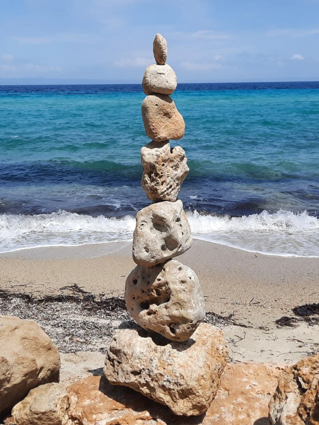 Stein-Collage am Strand mit Blick auf das Meer und den Himmel.