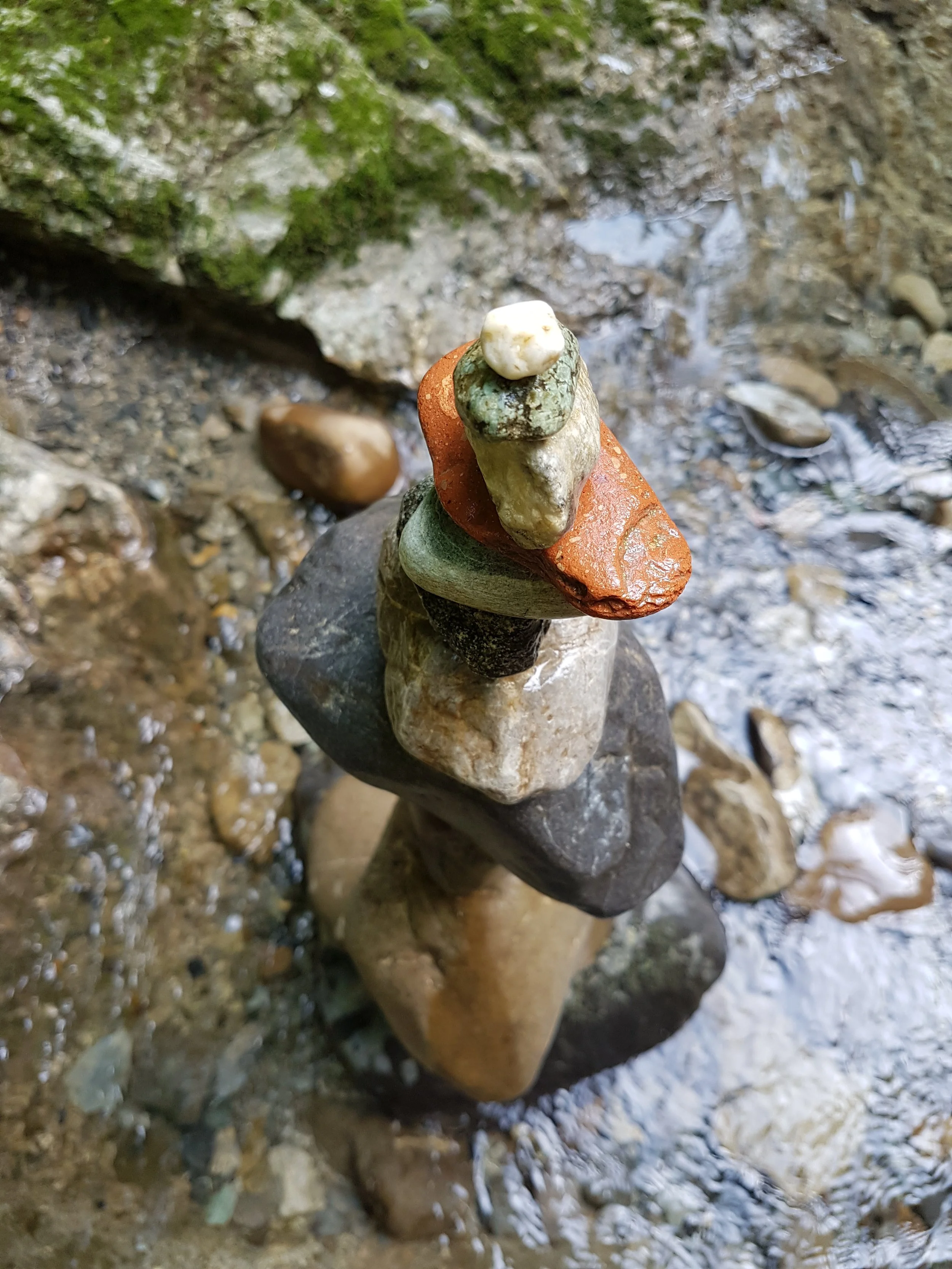 Ein Turm aus gestapelten Steinen auf einem Boden in einer natürlichen Umgebung.
