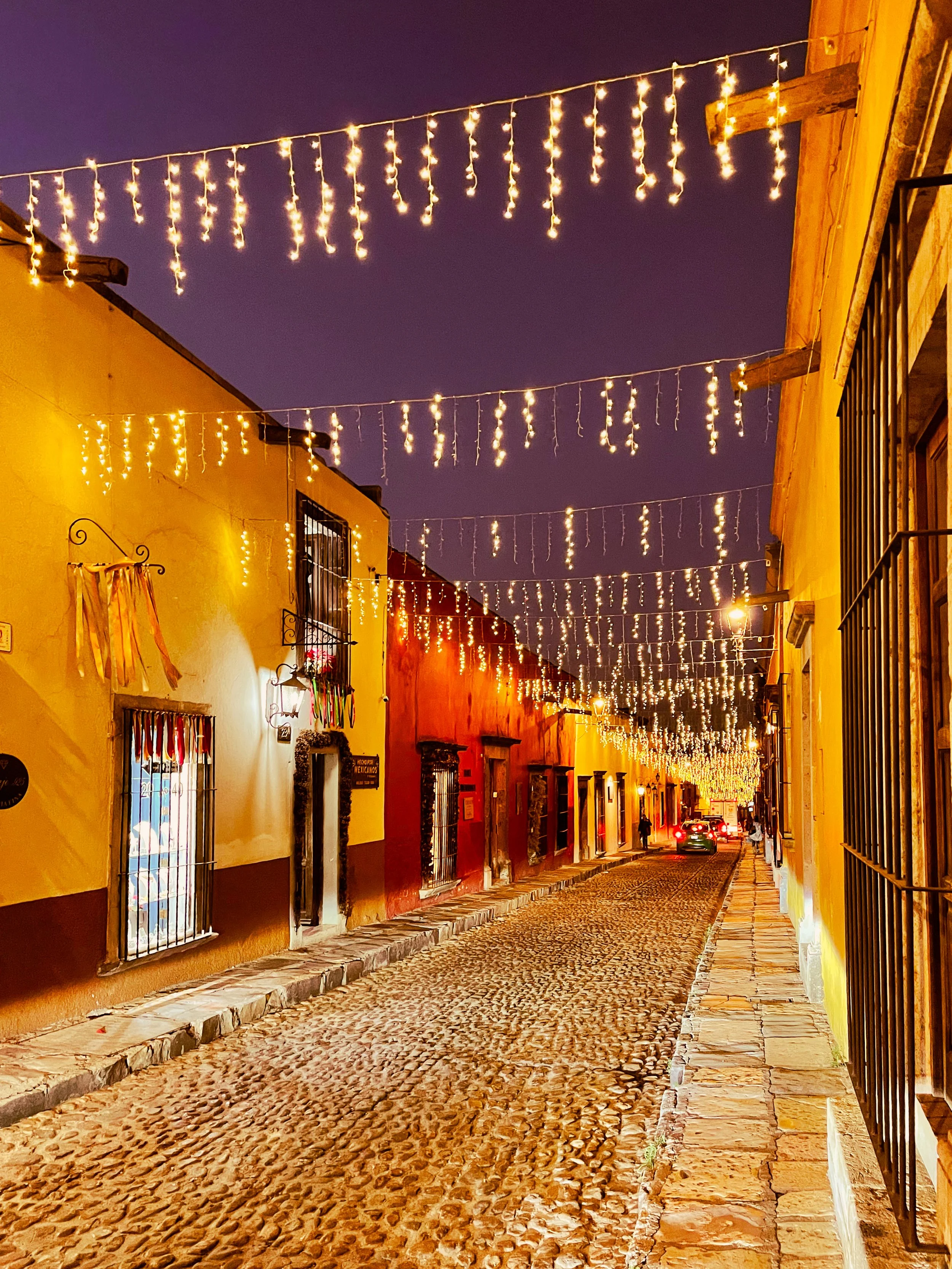 Street in San Miguel de Allende at night, lit up with lights draped across the buildings