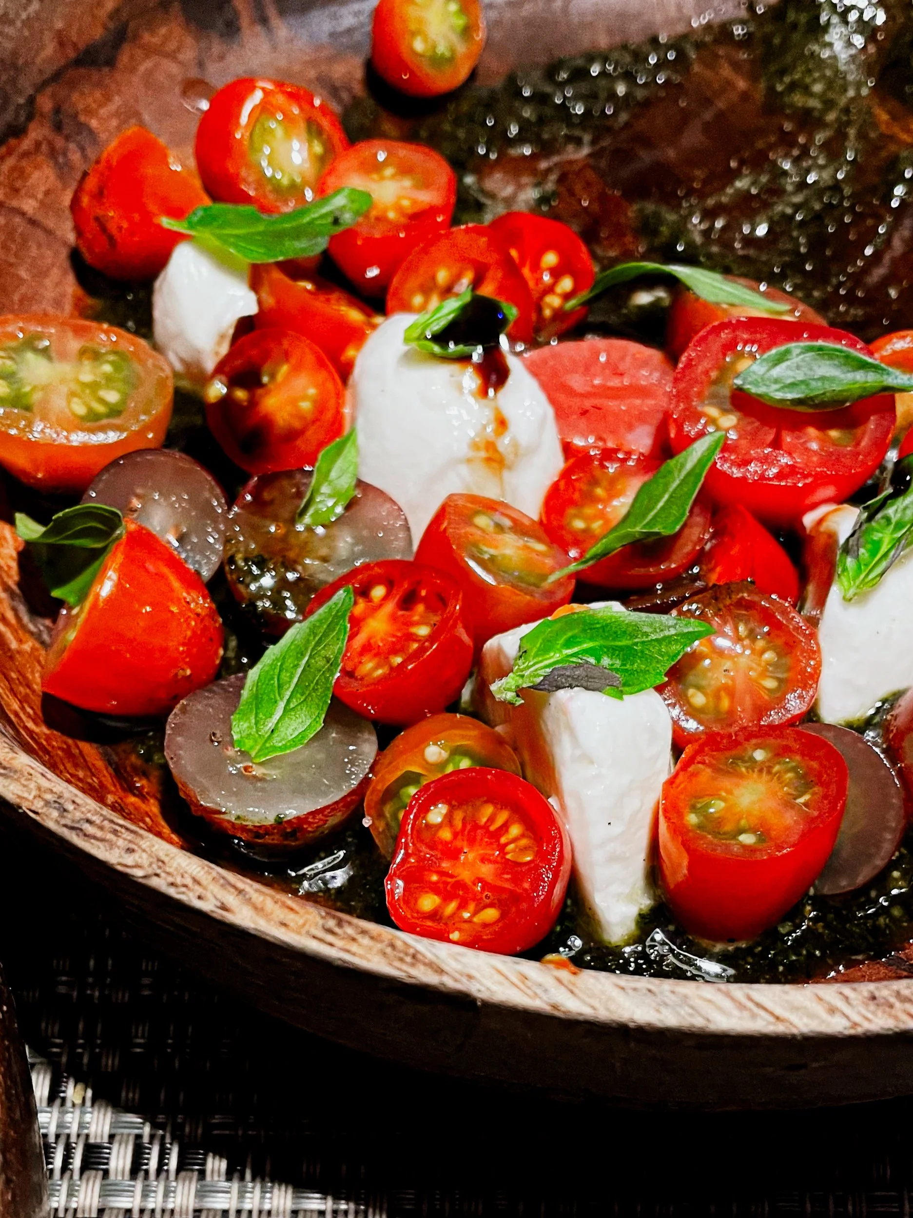 Plate of bright red tomatoes, basil and burrata