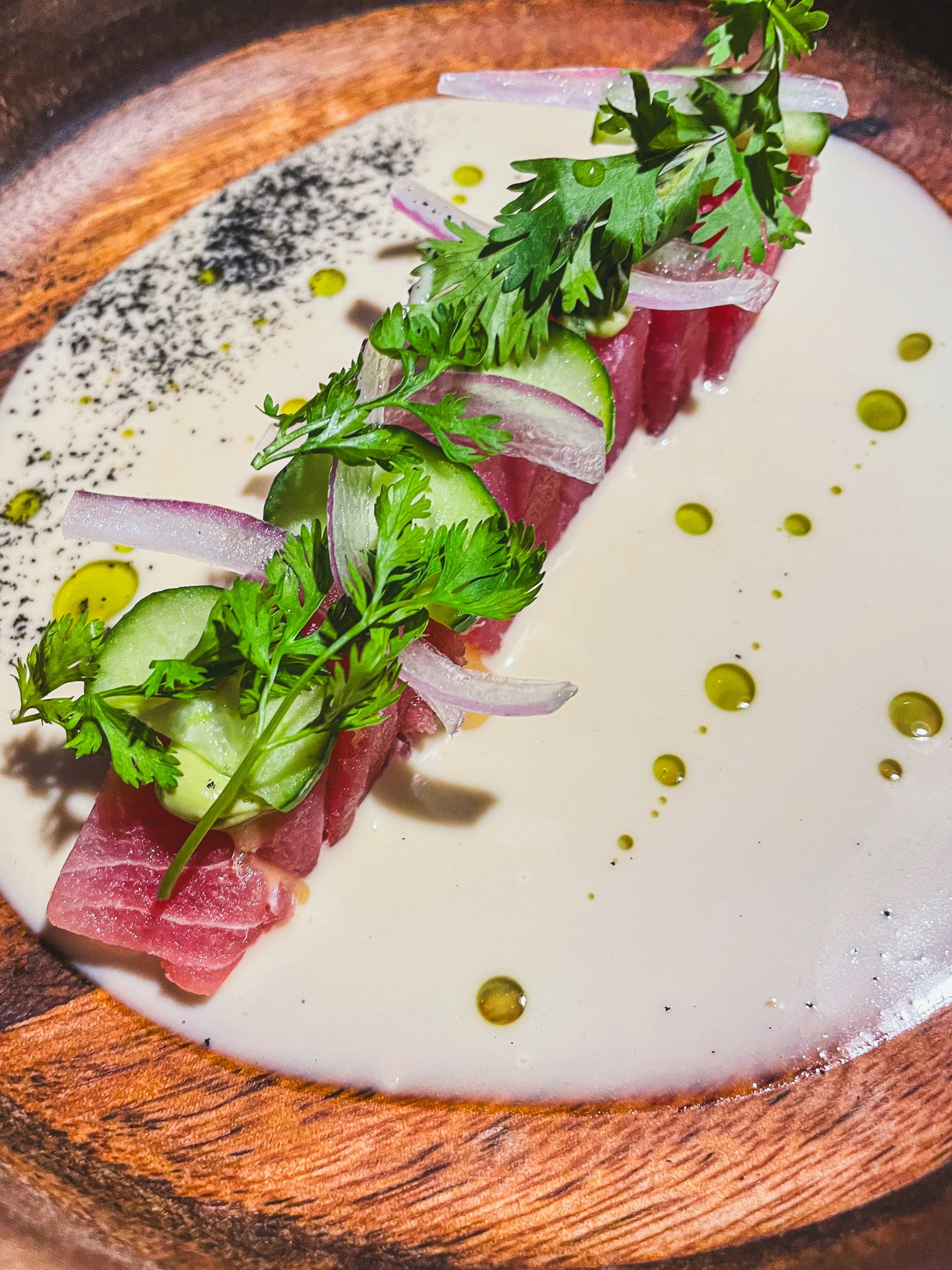 beautiful plate of ahi tuna with red onions, cucumbers and parsley