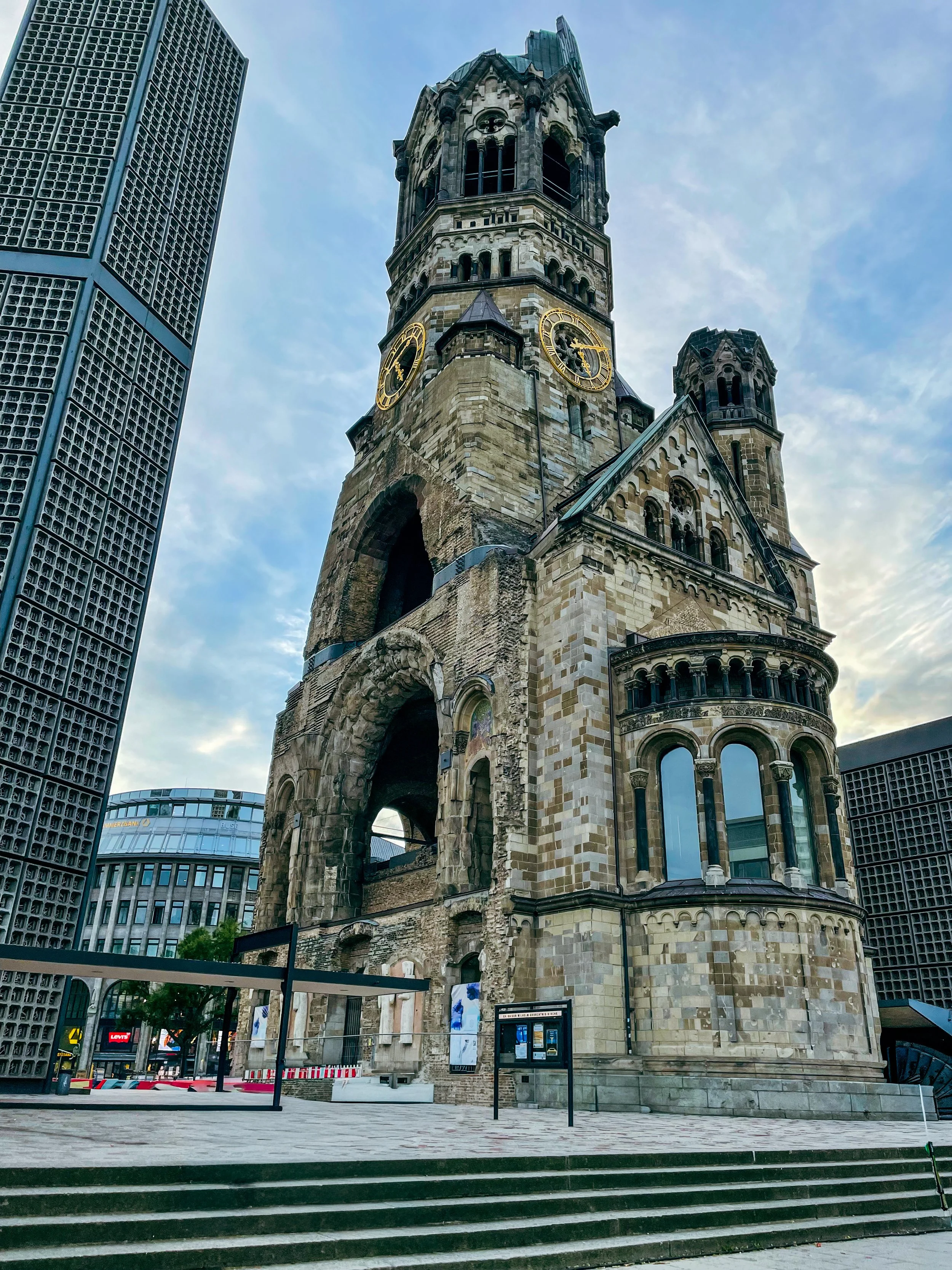 Juxtaposition of old bombed out Kaiser Wilhelm Memorial Church next to modern skyscraper in Berlin