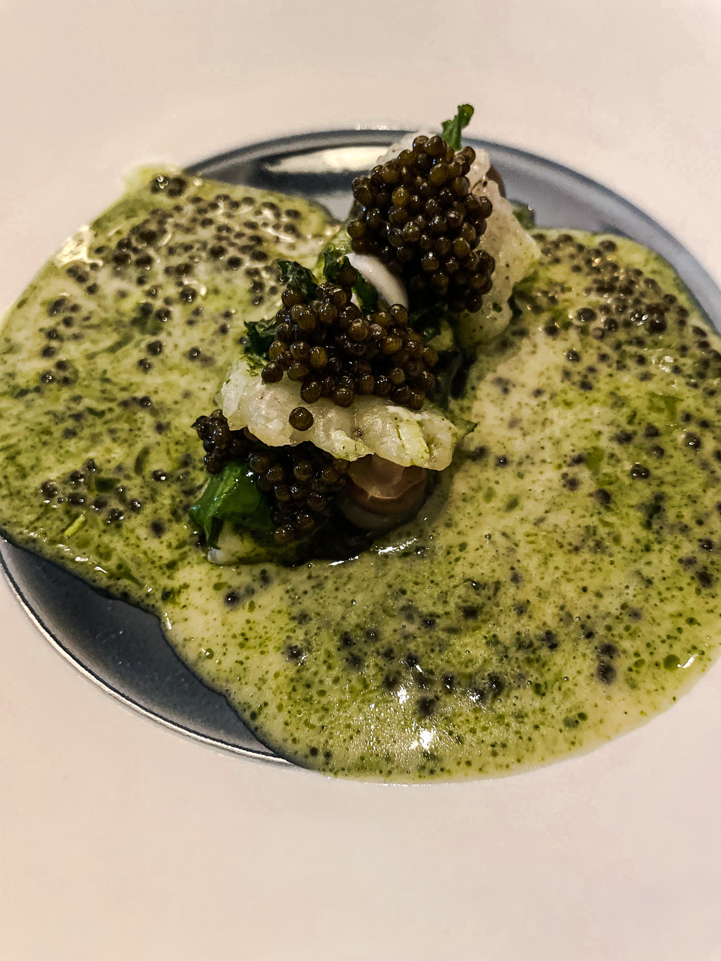 caviar atop a piece of fish in green sauce at Cordobar in Berlin