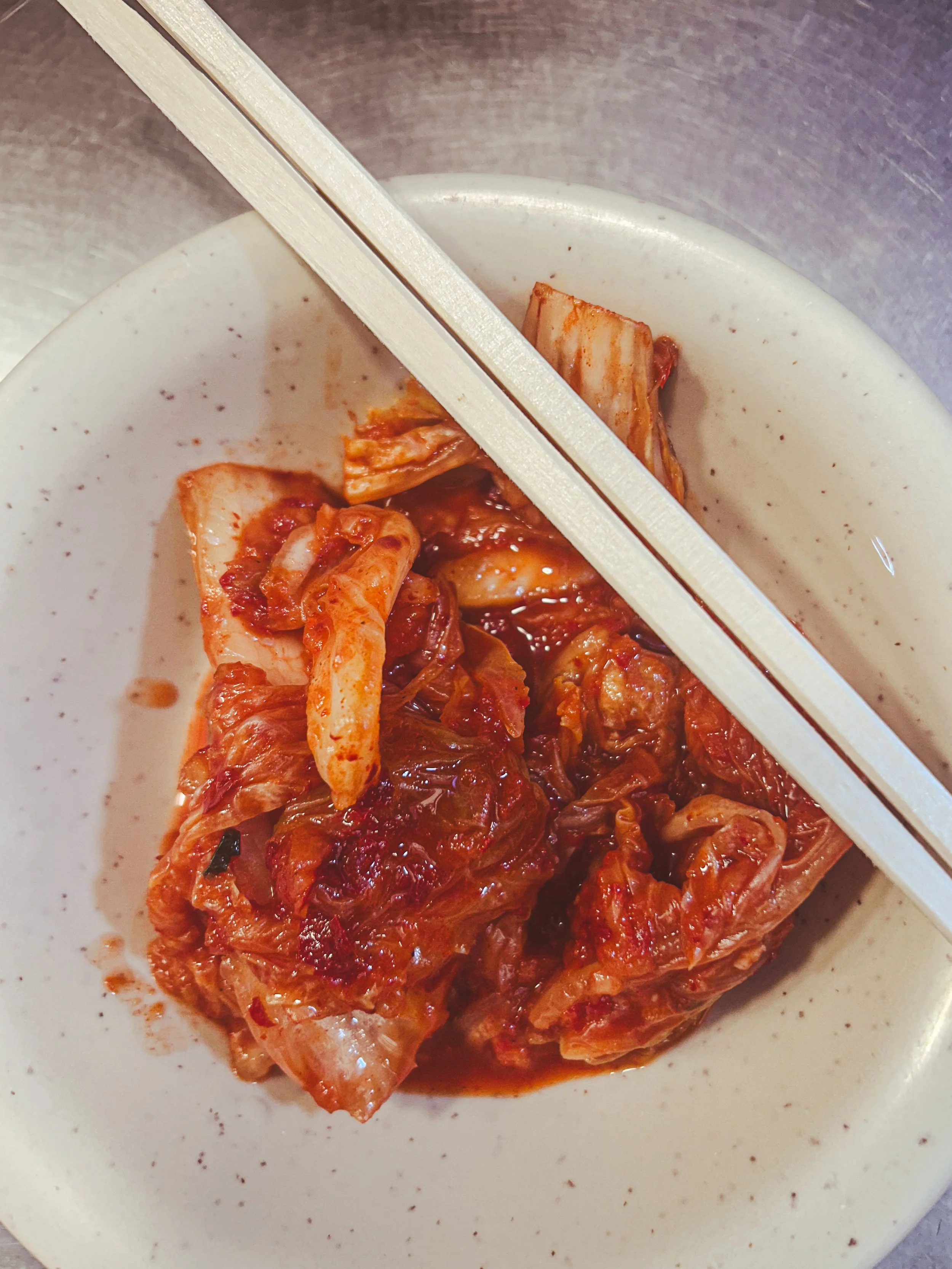 bowl of kimchi with chopsticks