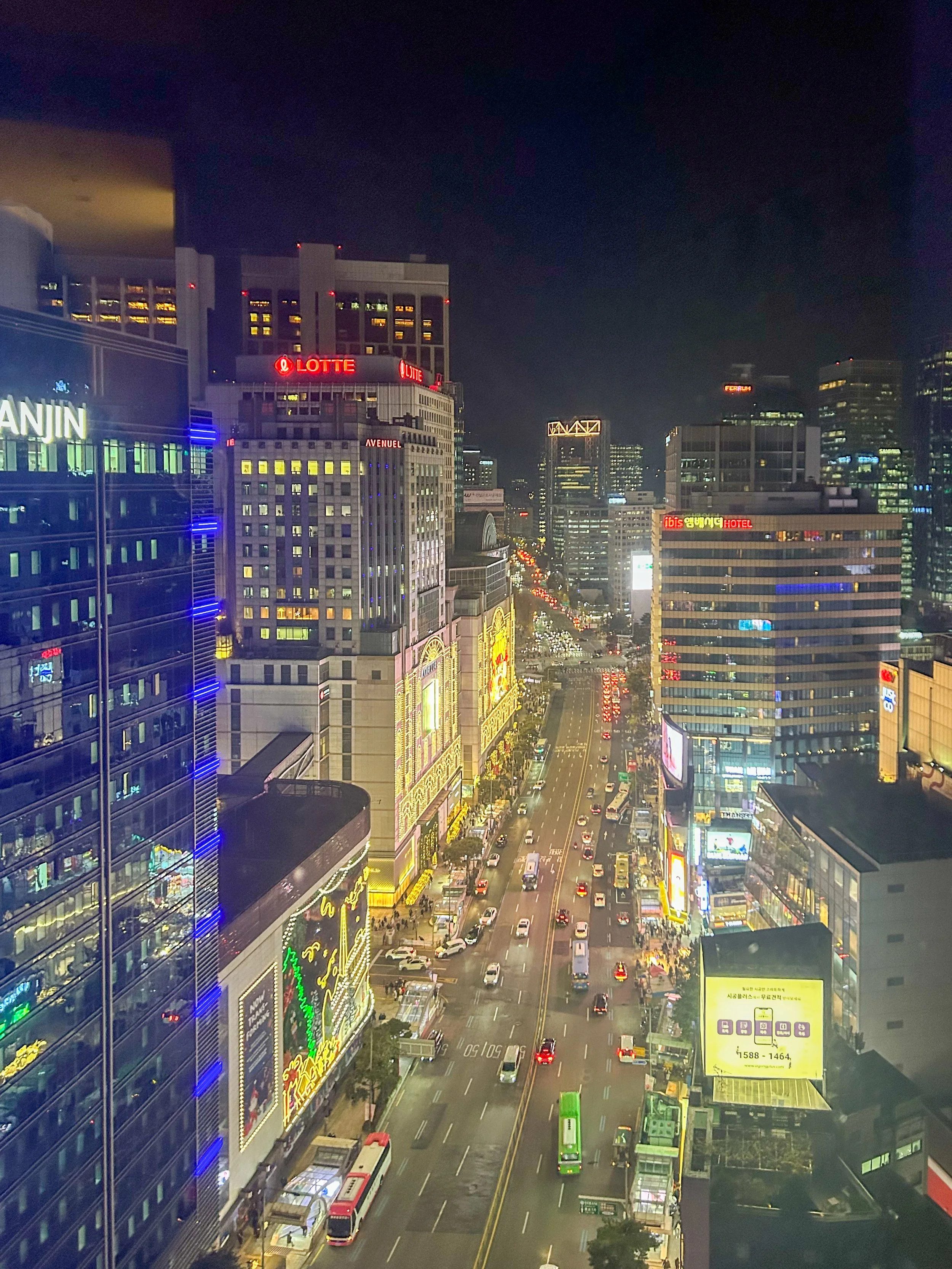 view down on busy Seoul street in Myeong-dong lit up at night