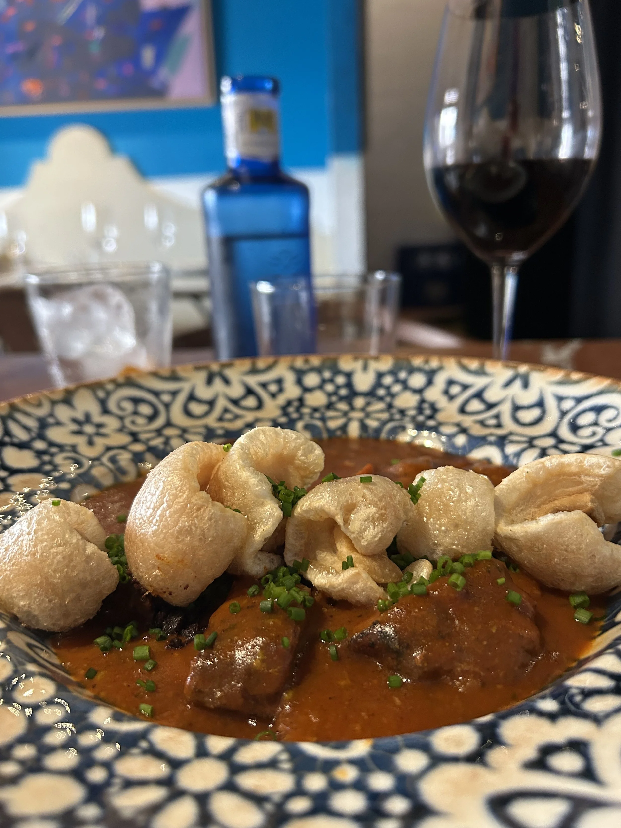 colorful dish and plate with a full glass of red wine at Taberna el Botero in Toledo, Spain