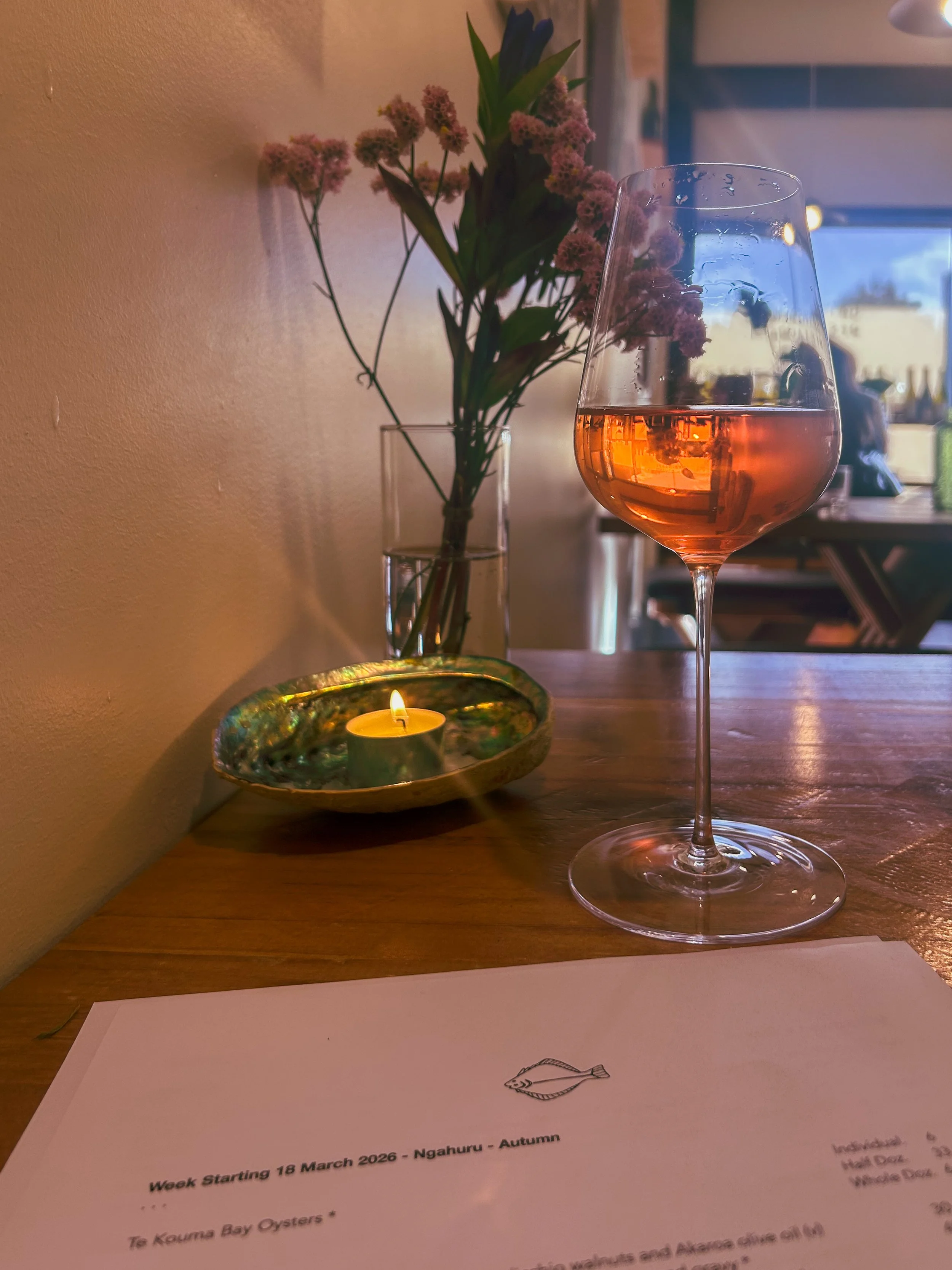 a glass of wine on the bespoke wooden table at Gatherings in Christchurch, New Zealand