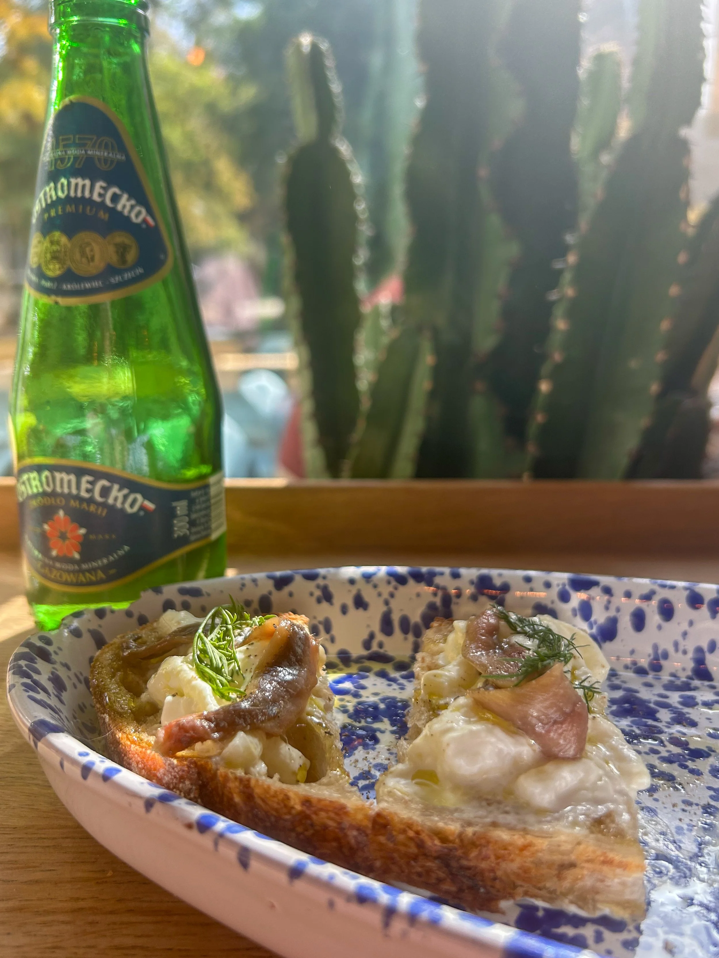 Anchovies on Toast in front of sunny window at Bianca in Warsaw, Poland