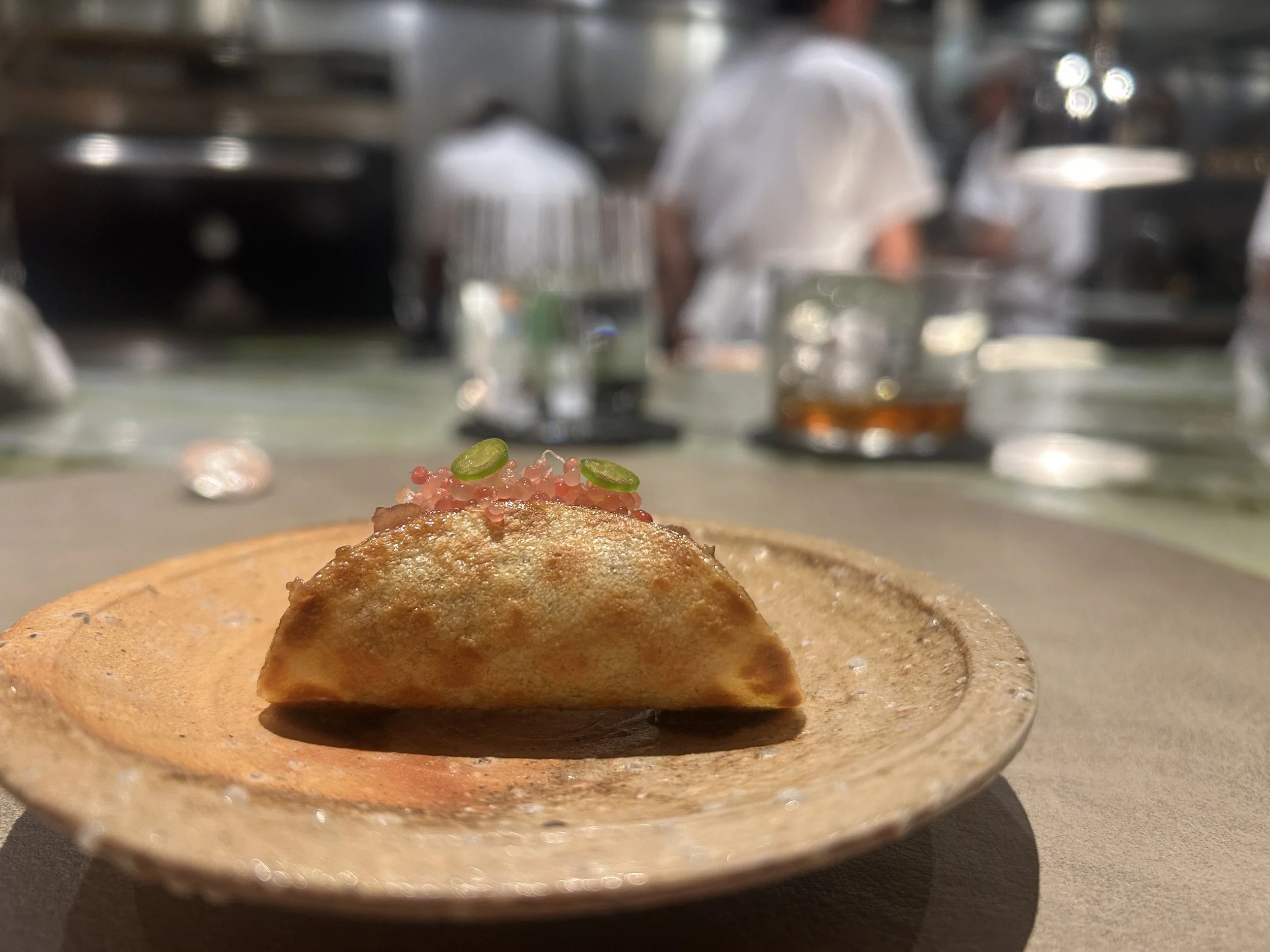 The Pin in the background of a plated dish at Quintonil in Mexico City