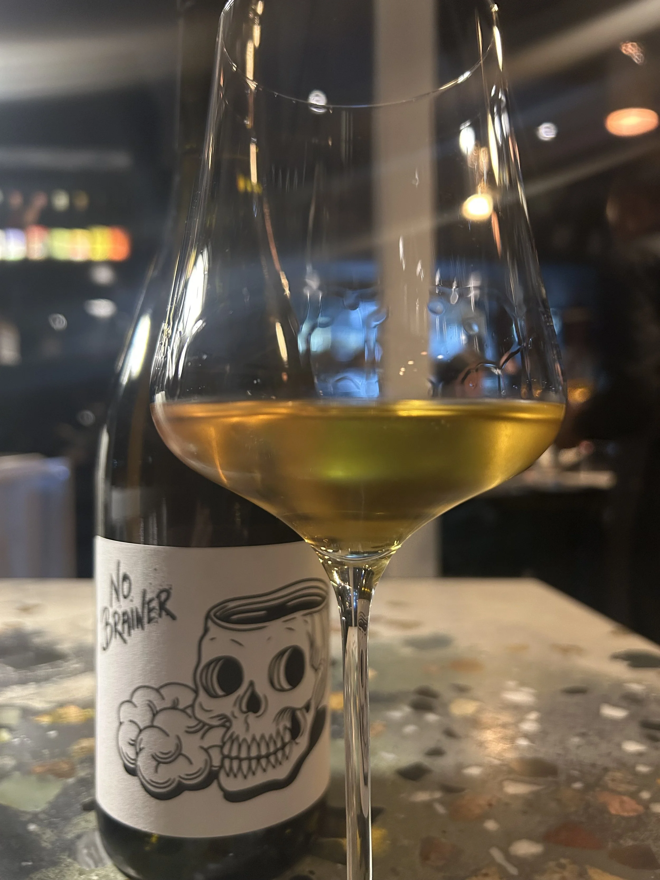 Glass of wine and tattoo label art from Seembamboes Collaboration Dinner in Cape Town, South Africa