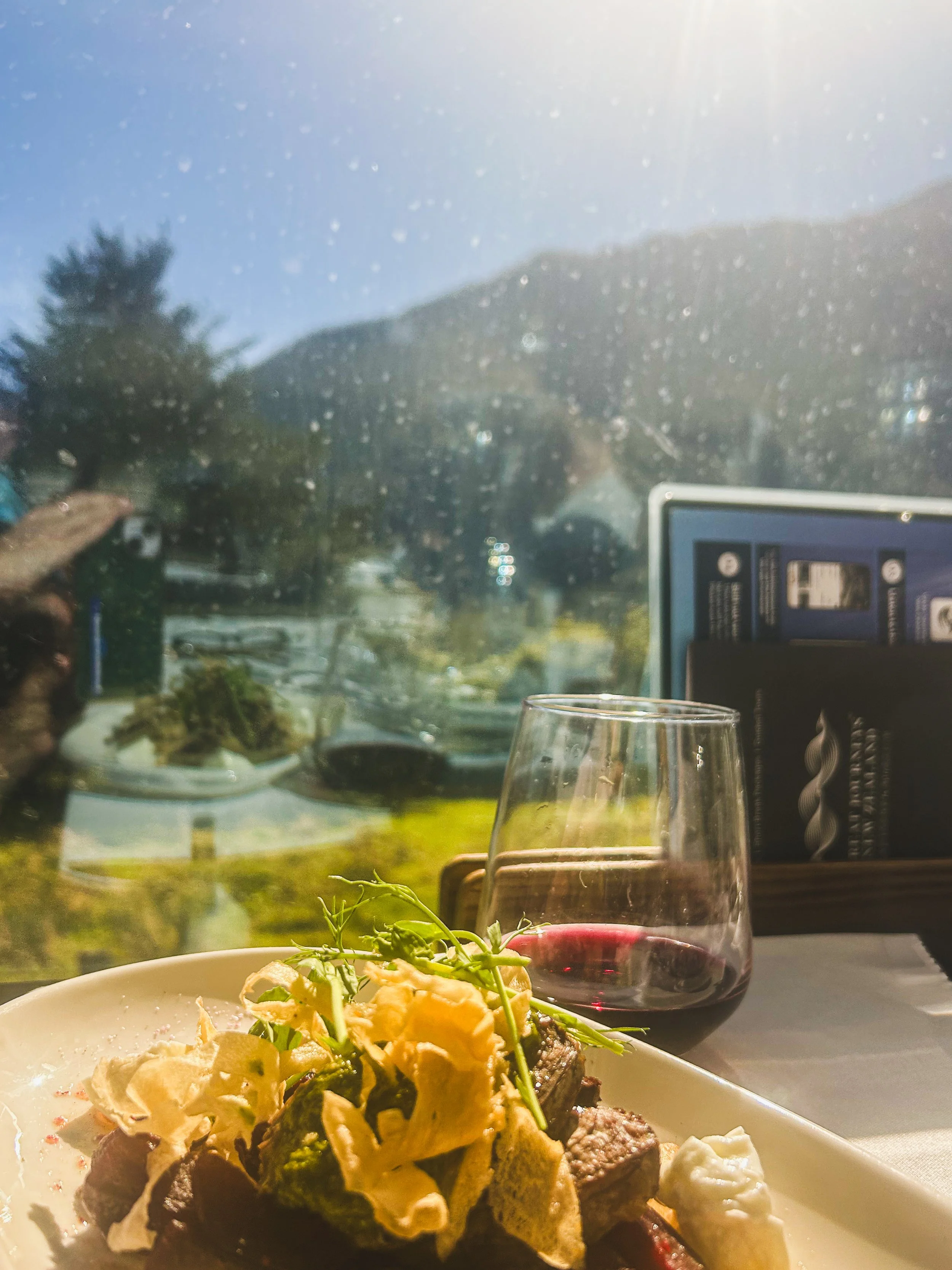 lamb entree  and glass of red wine from the Scenic Plus dining car of the TranzAlpine train