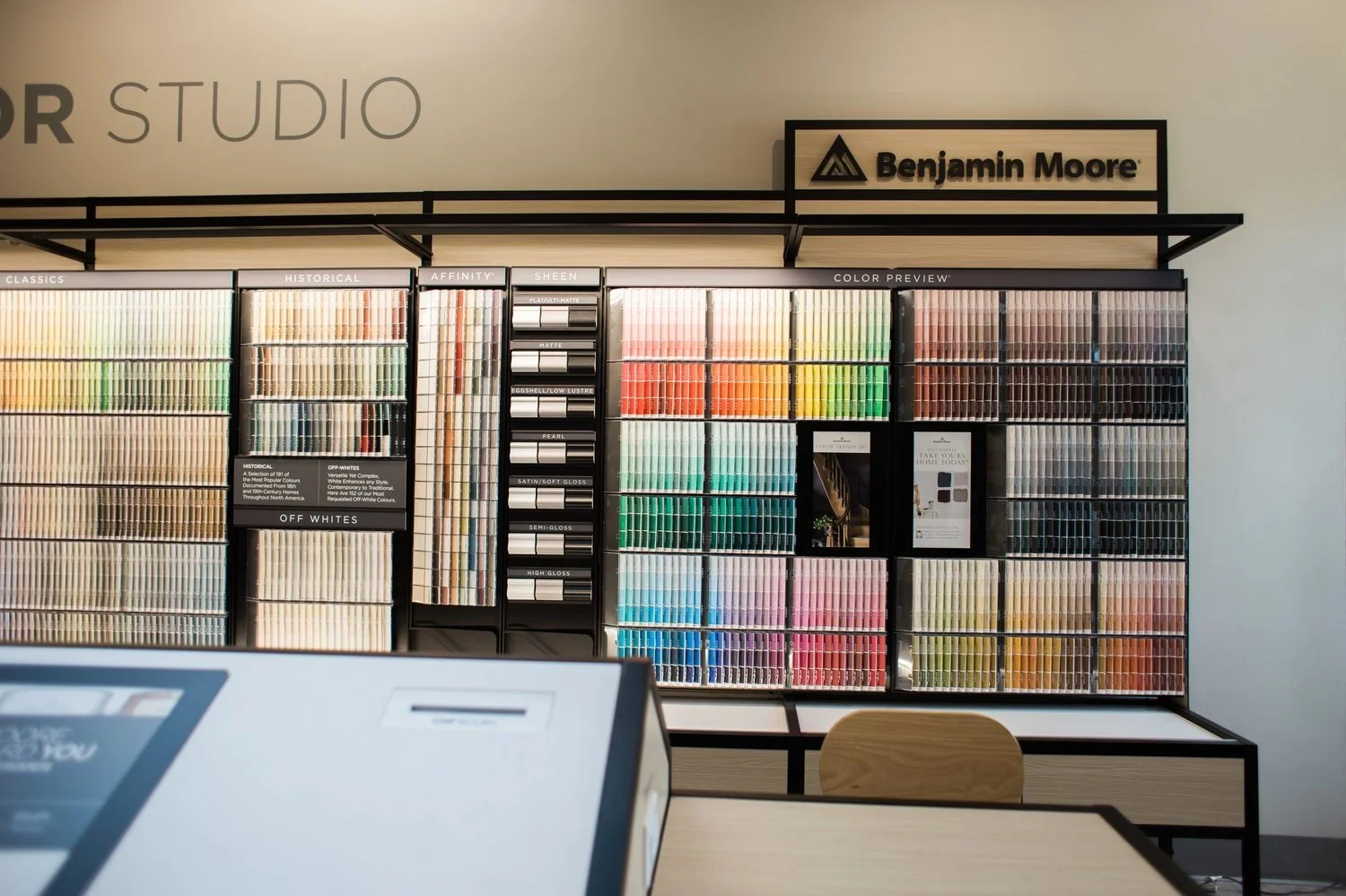 Benjamin Moore paint color display with color samples and brochures in a store.