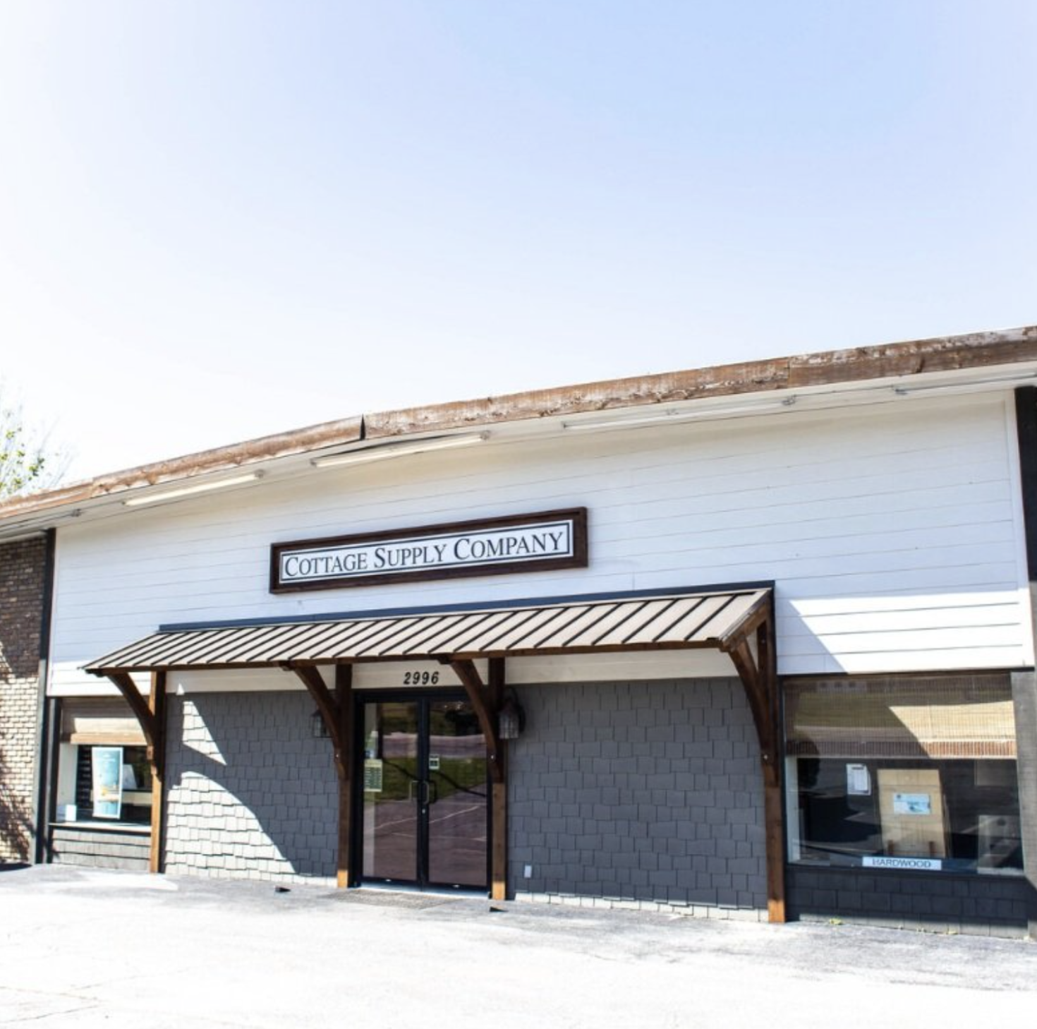 Exterior of Cottage Supply Company building with small awning and large window. Pelham, AL