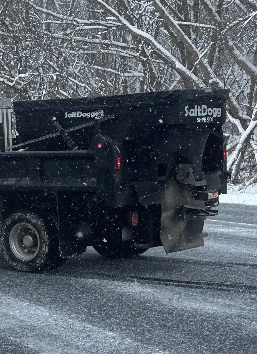 Truck-mounted salt spreader prepared to de-ice commercial pavement during a winter storm in Western New York