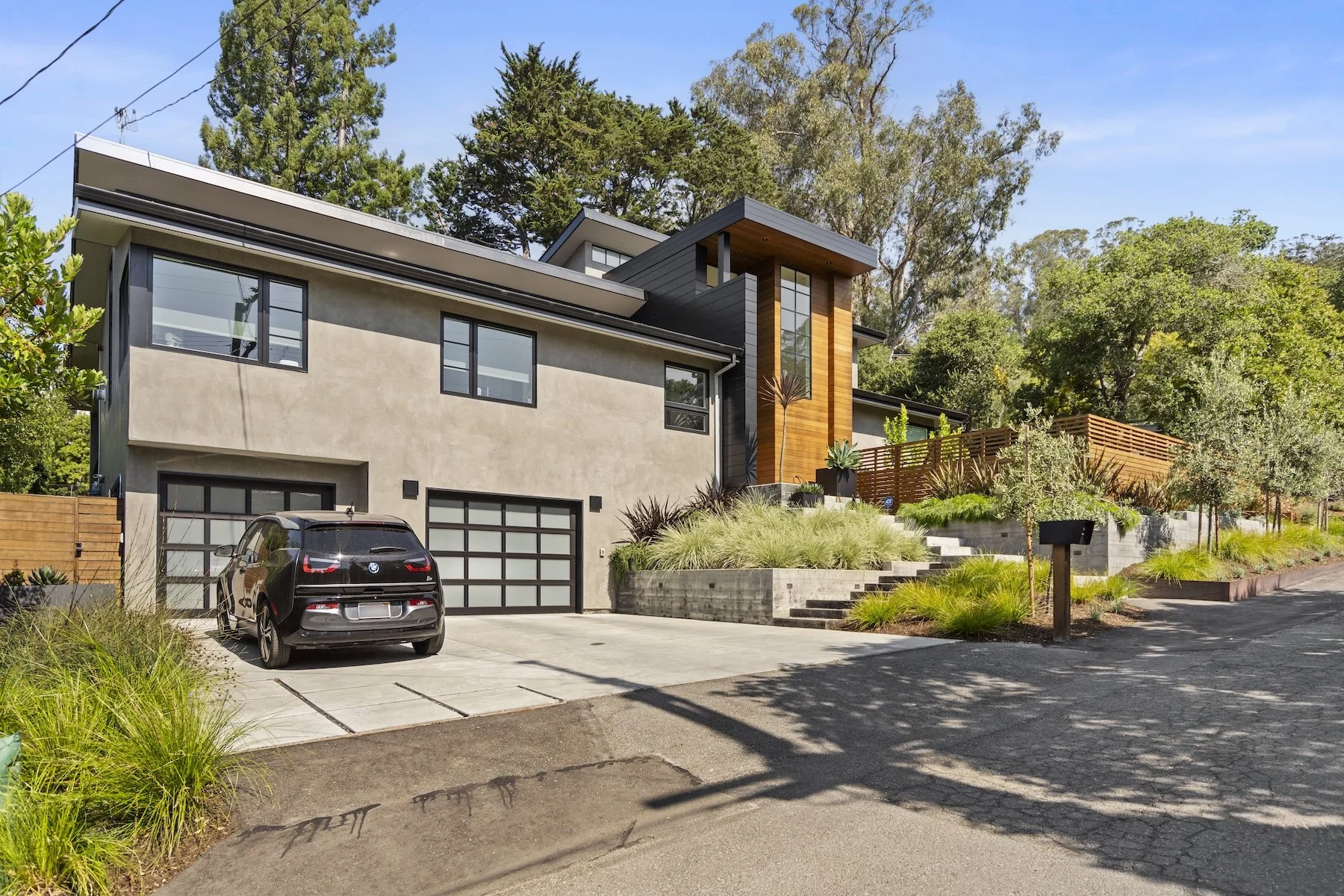 Front of modern home with concrete driveway and plantings