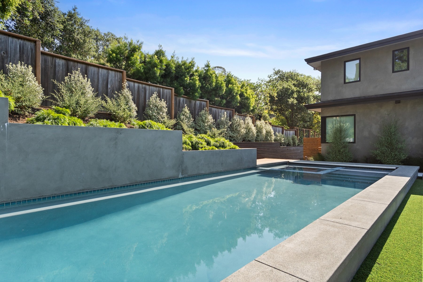 Inground pool and raised planters and retaining walls in backyard of home