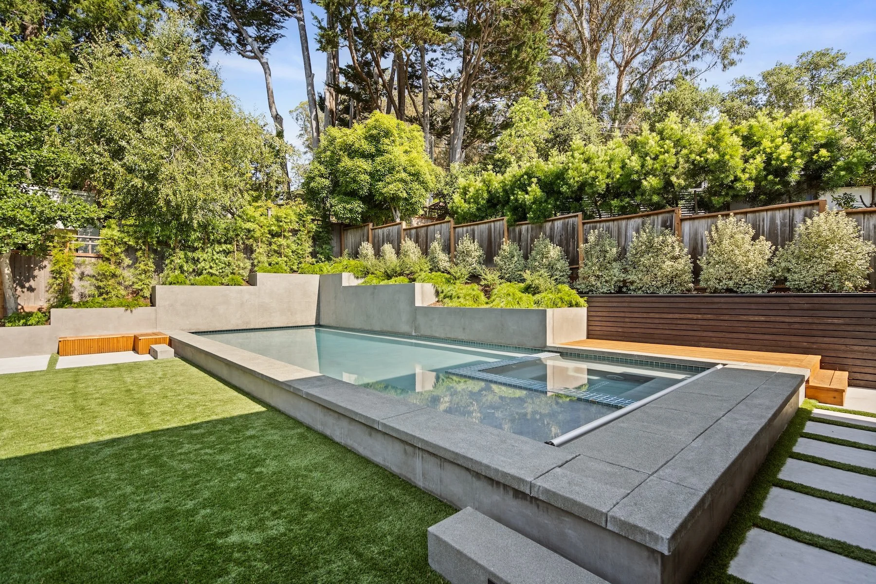 Inground pool, artificial turf, raised planters in a modern backyard