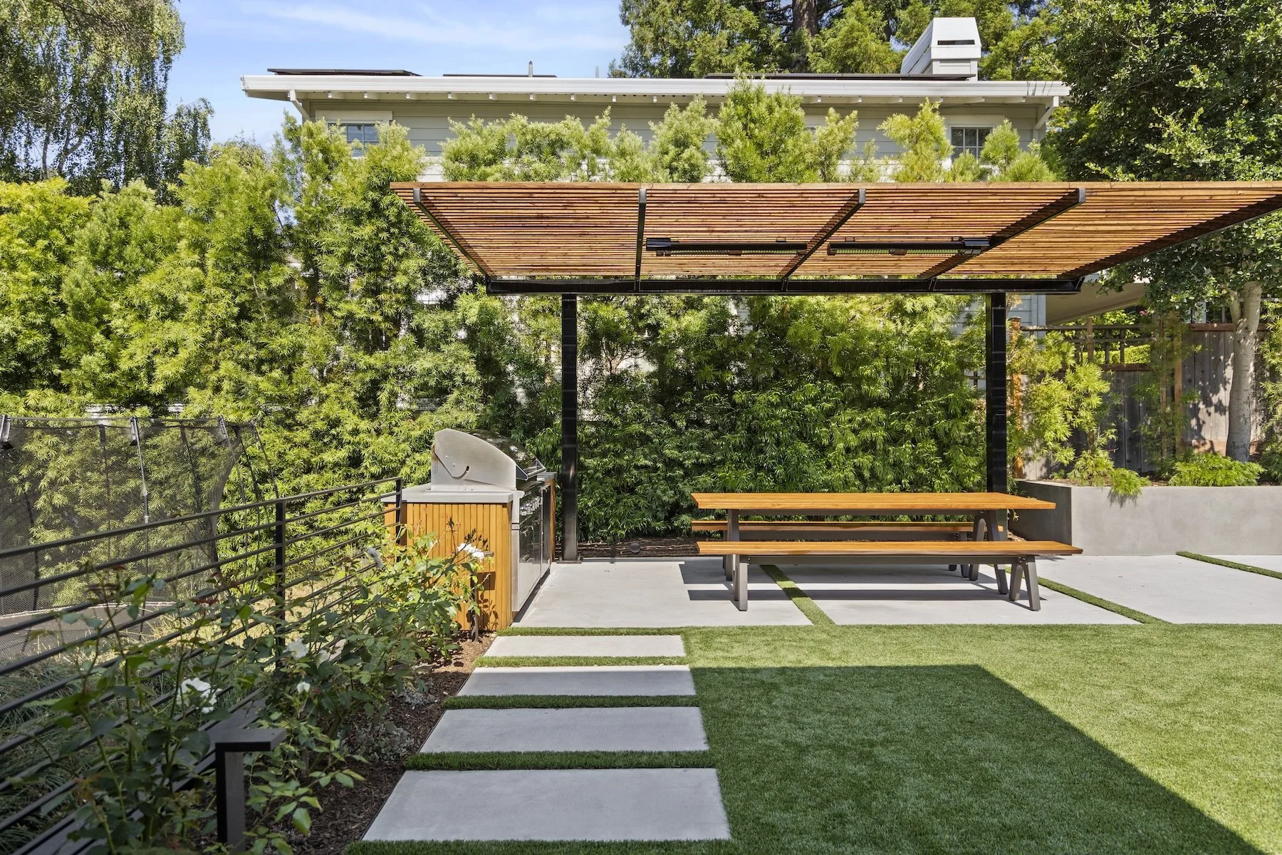 Wooden pergola with outdoor kitchen and picnic table