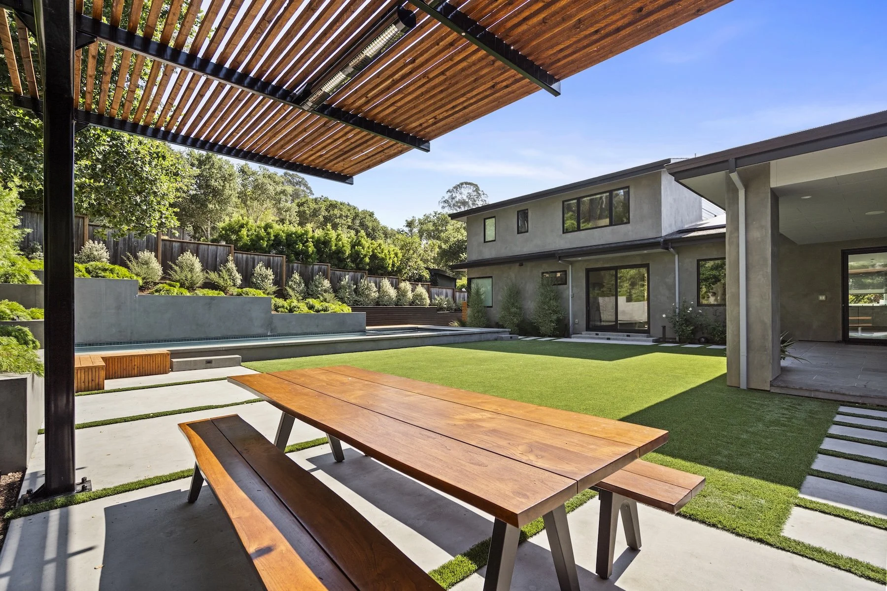 Picnic table, artificial turf backyard, under wooden pergola