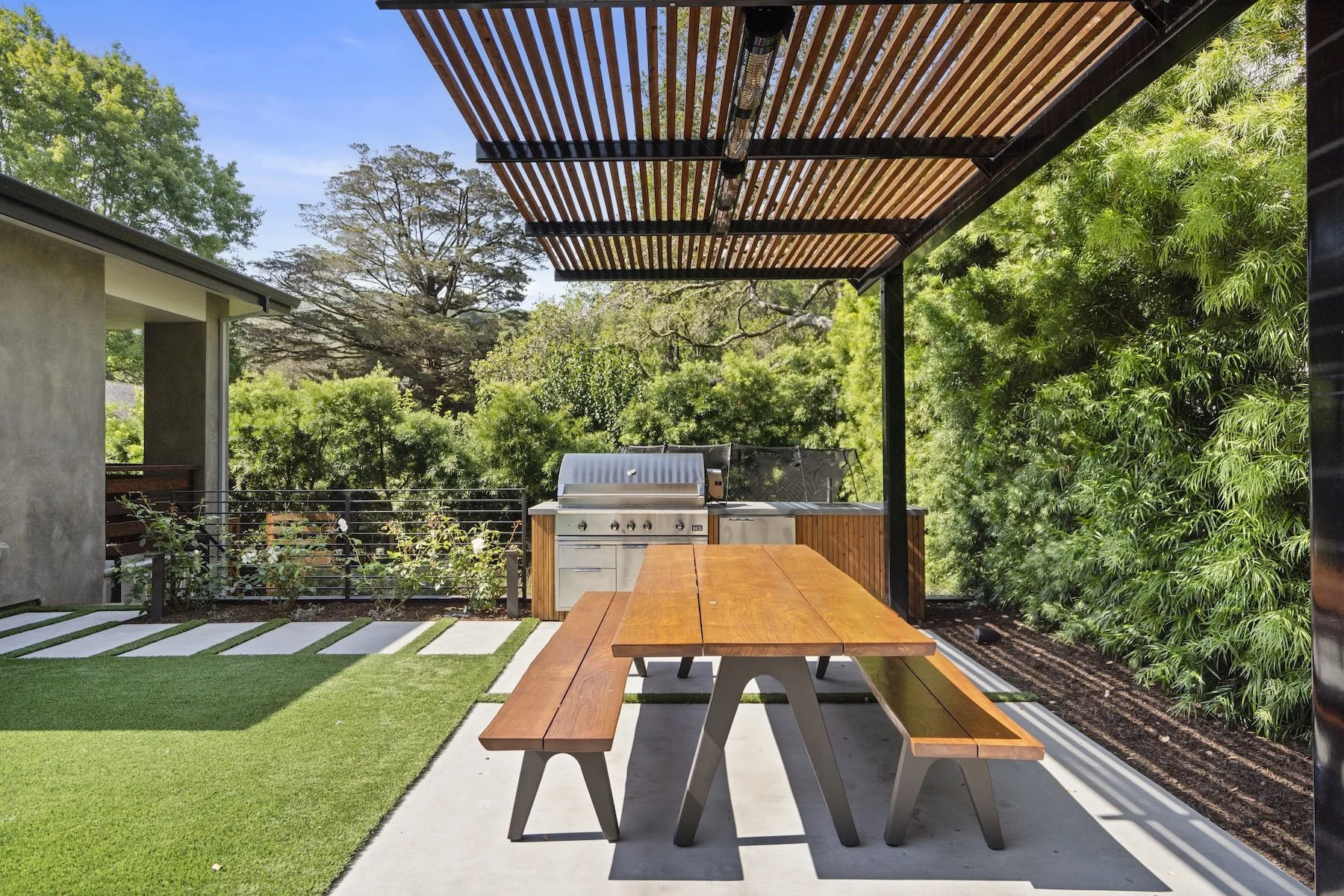 Wooden pergola and outdoor kitchen with wooden picnic table